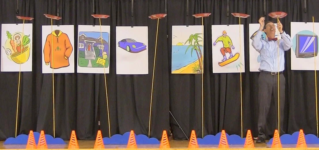 Plate spinning and comedy get kids excited as they learn about balancing needs and wants.