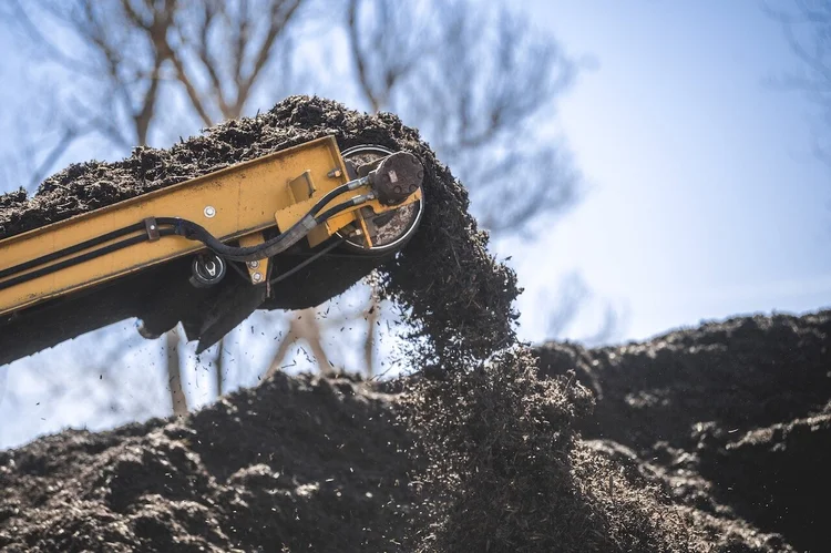 Compost pouring from a loader bucket