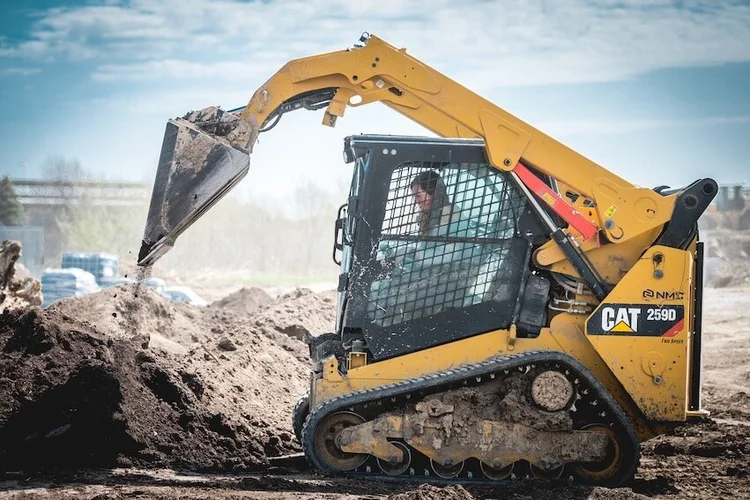 Skid steer loading compost into a pickup