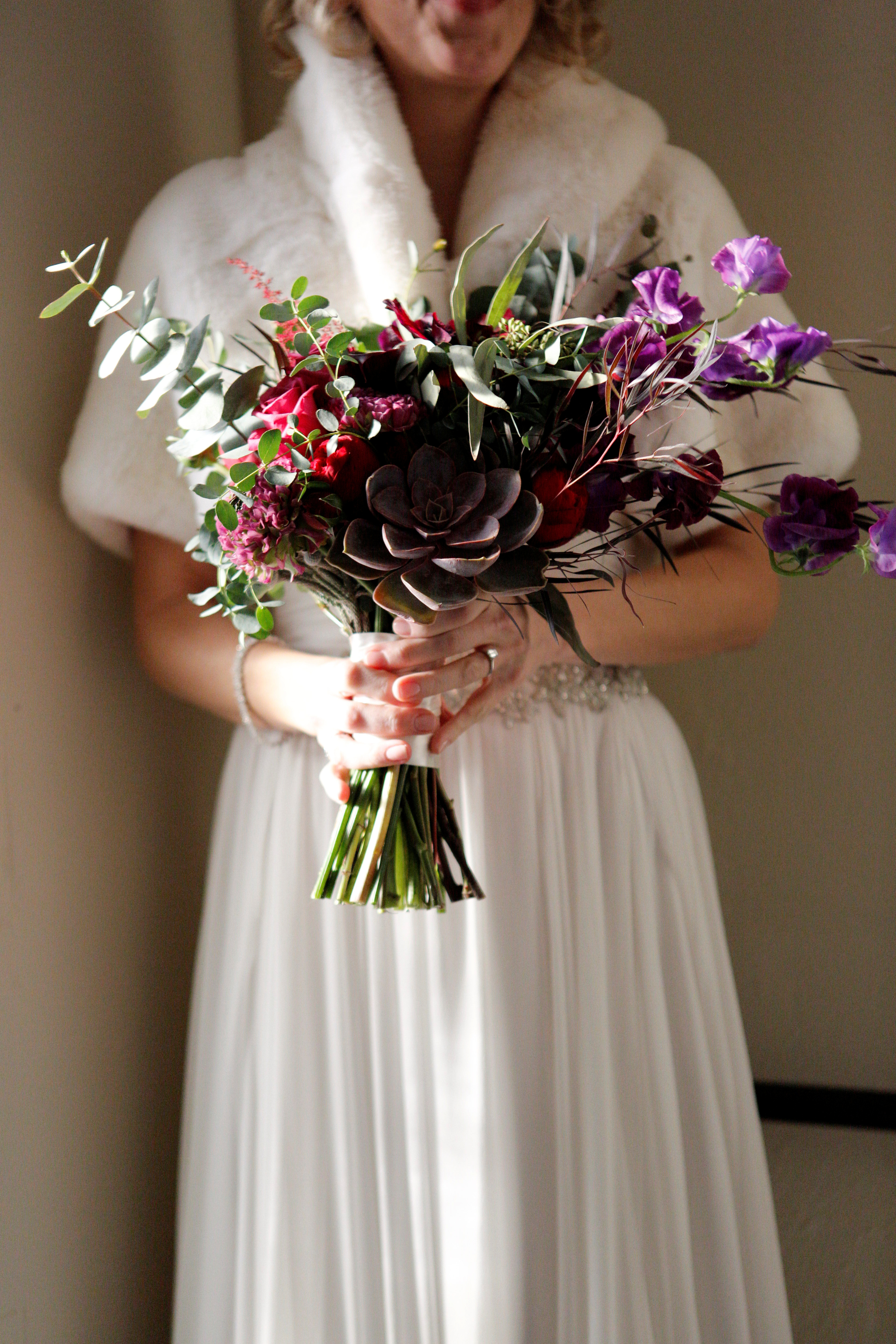 Purple bridal bouquet featuring sweet peas and succulents in purple