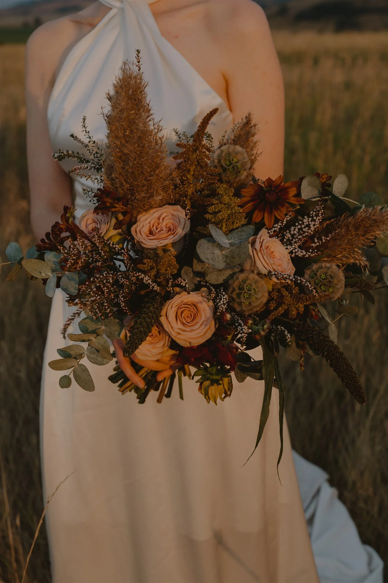 roses, scabiosa pods , amaranth, calycina, eucalyptus, pampas, millet bouquet for a Wyoming wedding with flowers by Sheridan florist, Whirly Girl Flowers