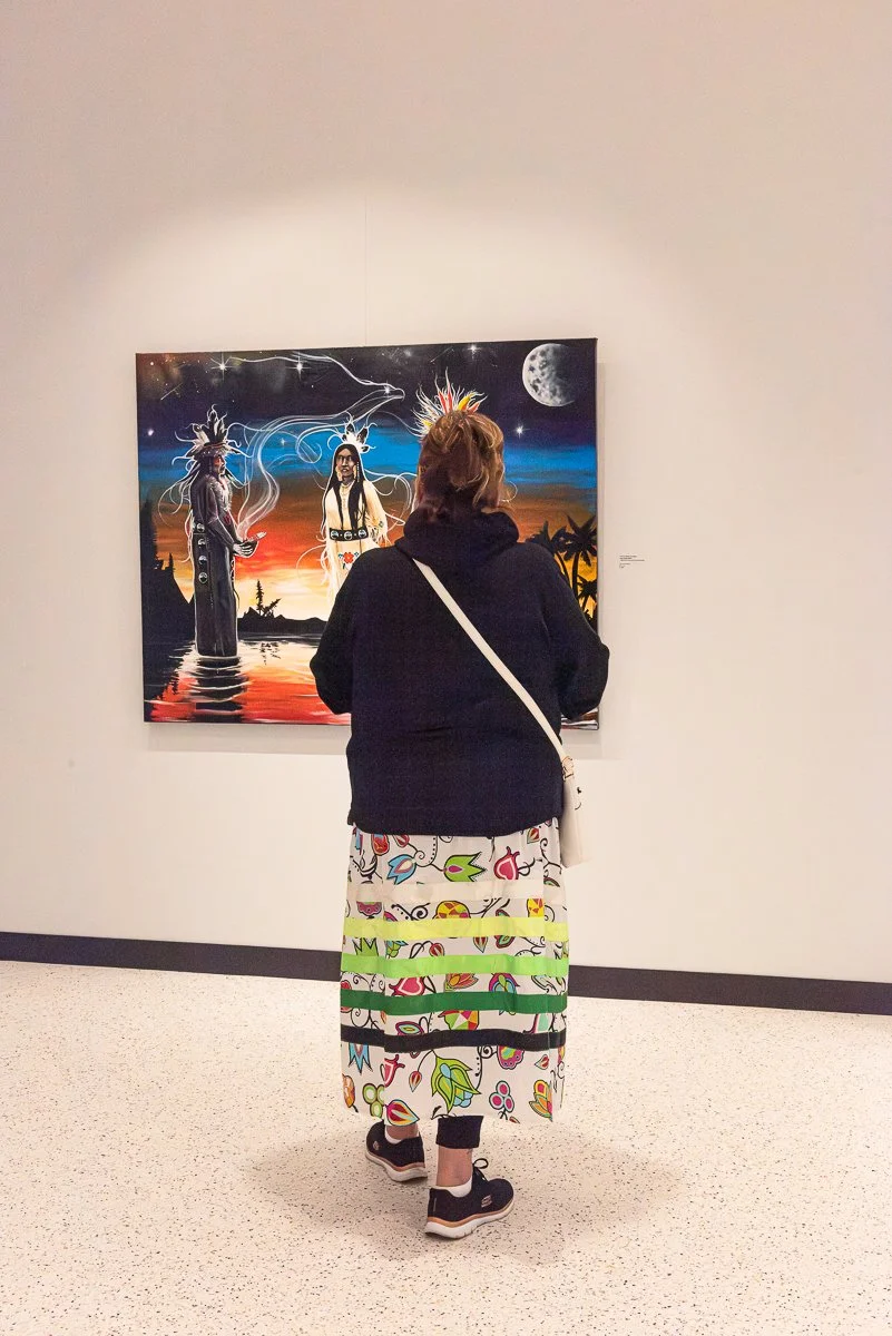 A gallery visitor viewing art installed at Two Rivers Gallery