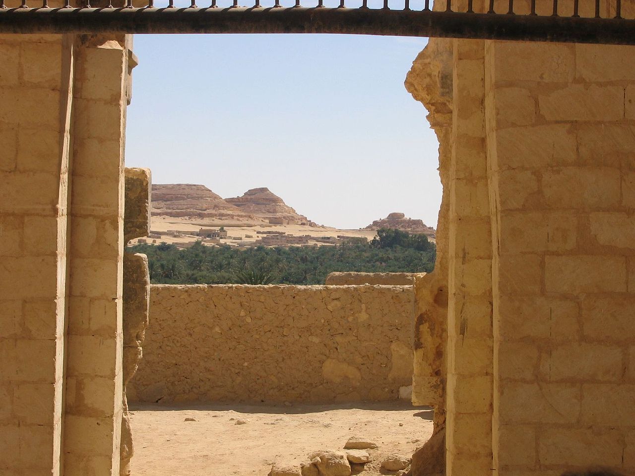 A view from inside the ruins of the Temple of Amun toward the surrounding oasis and desert.