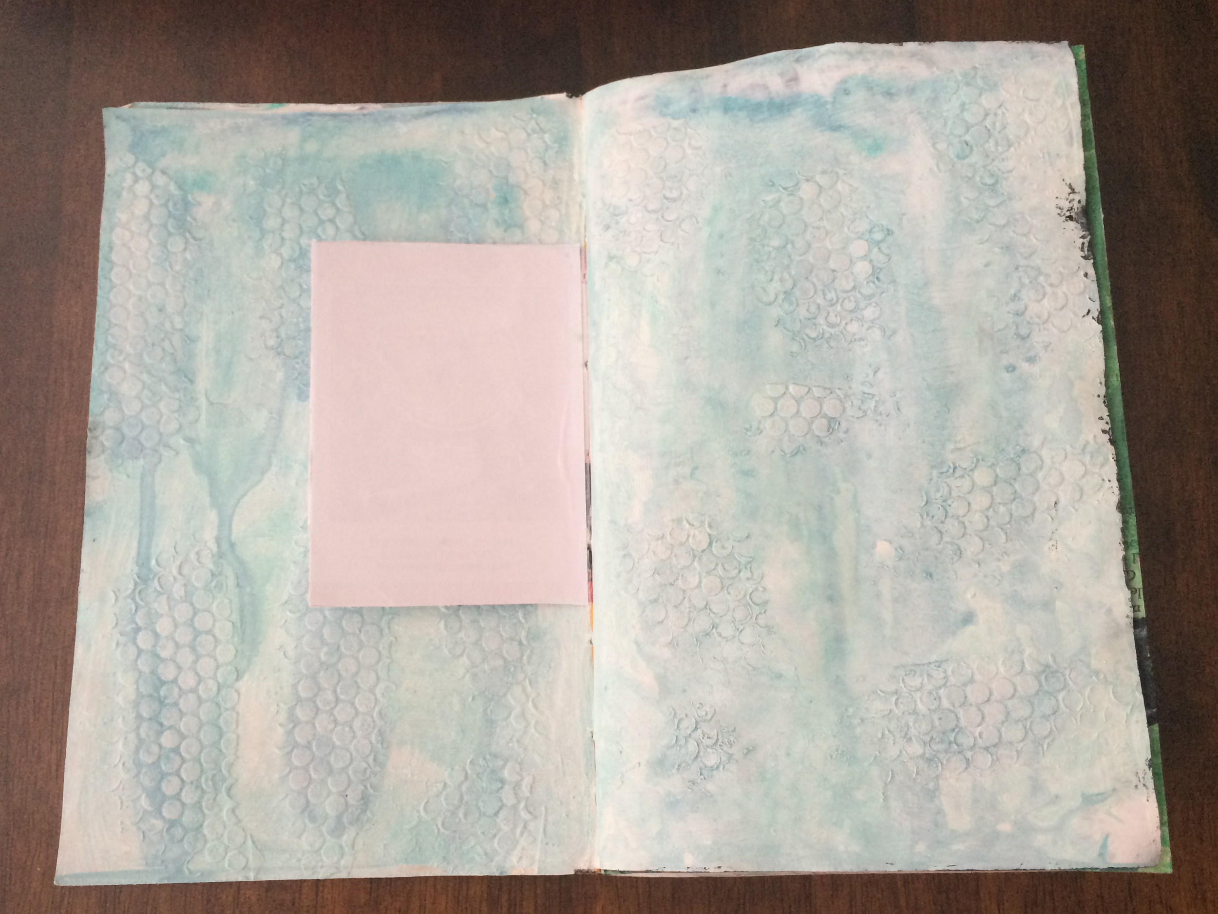 This page isn't completed yet. I had some ideas of where it should go, but it just hasn't materialized yet. I'm fine with that. Here is what I've done so far: 1) Generously cover both pages with white gesso. Both pages started with a lot of color and I wanted that covered up. 2) Added texture paste with dot stencil. 3) Apply watered down acrylic paint in teal and navy.