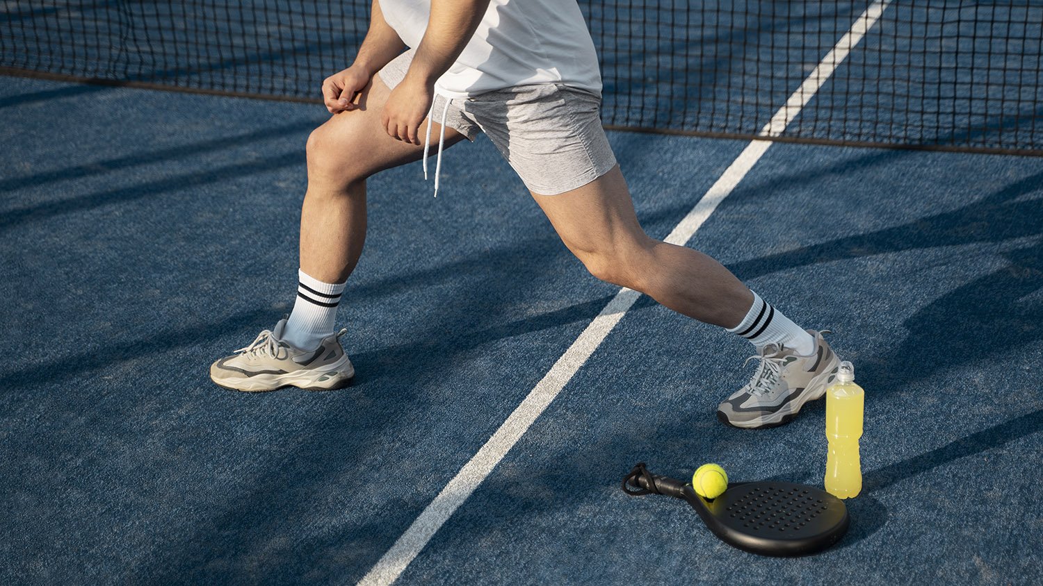 Pickleball player stretching and warming up on court demonstrating injury prevention techniques taught at Victory Performance PT Culver City
