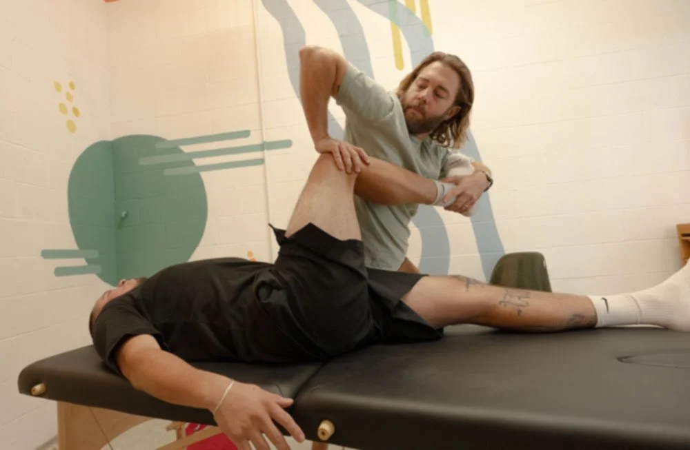 Physical therapist assessing a patient's hip in side-lying on a treatment table at a Mar Vista clinic