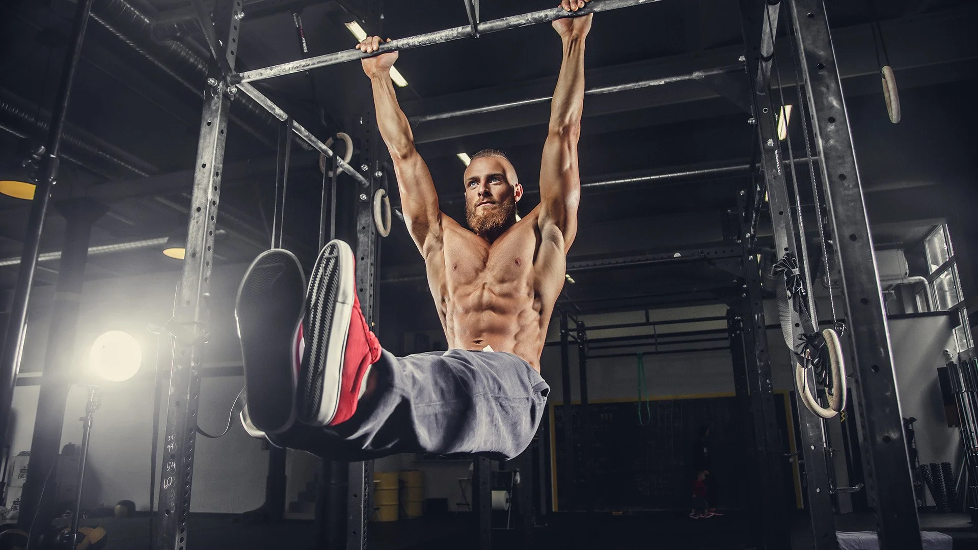 Athlete doing hanging ab exercise showing proper form for functional fitness training