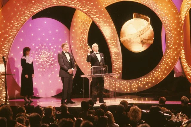 Set design (and background neck doily) Golden Globes circa 1987 via architecturaldigest.com