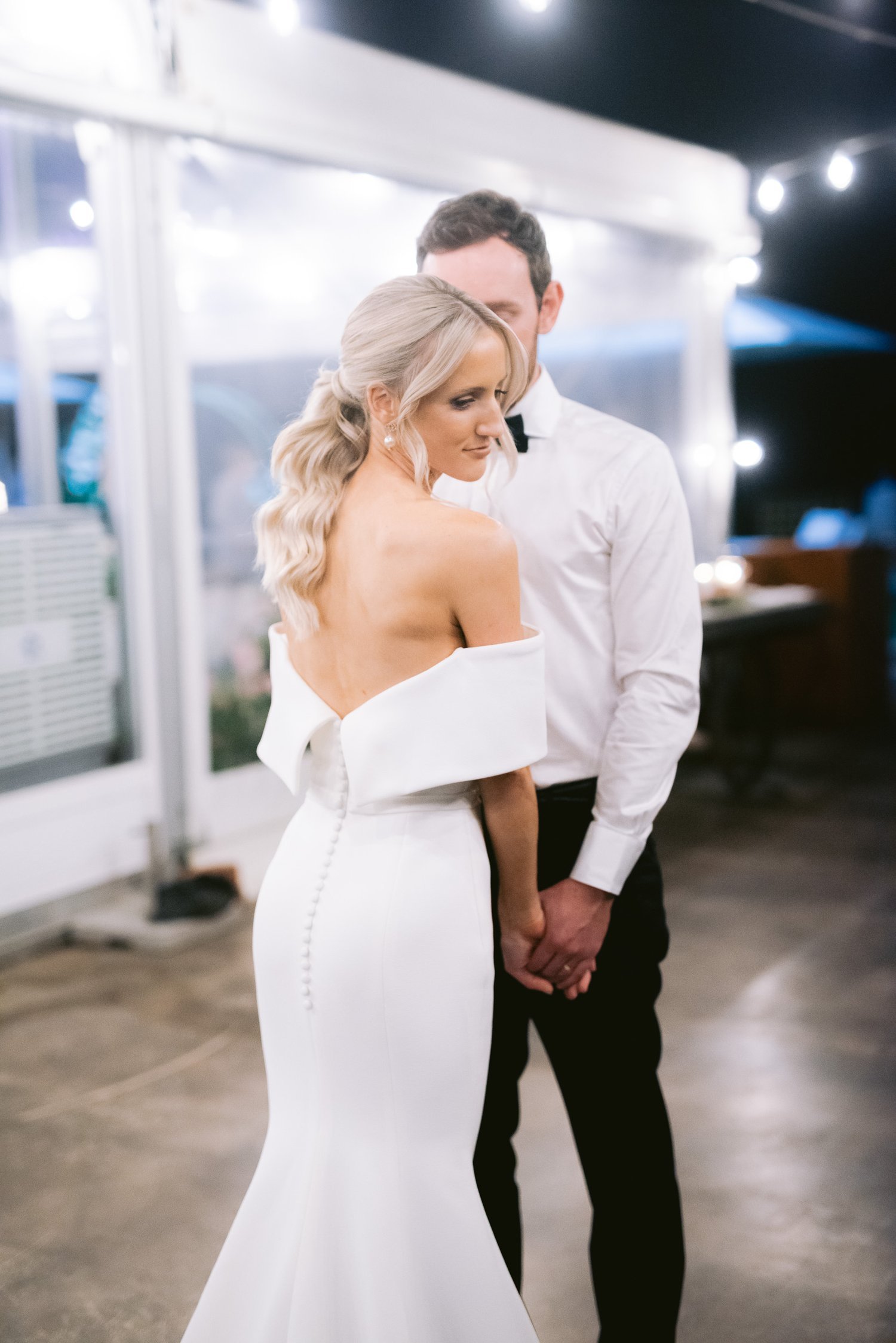 Couple holding hands, bride in white dress, wedding setting
