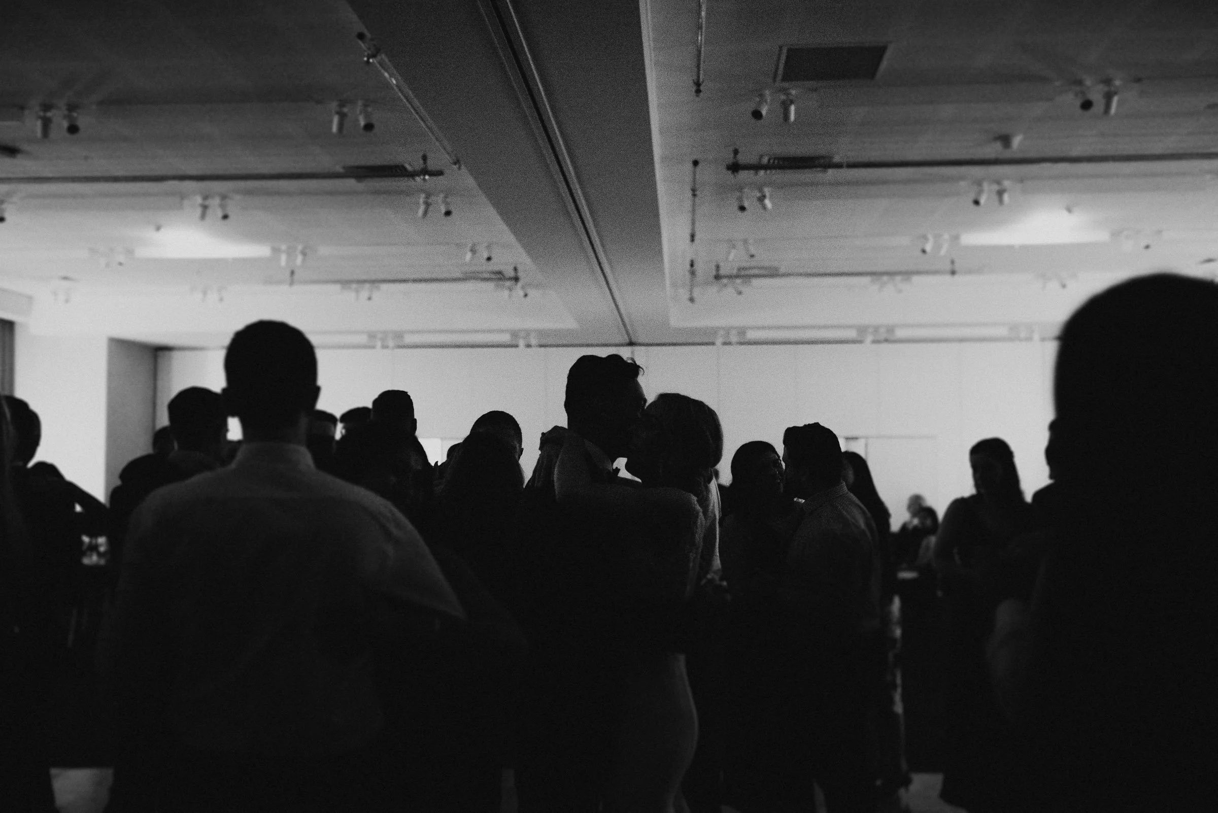 Silhouettes of people dancing in a dimly lit room.