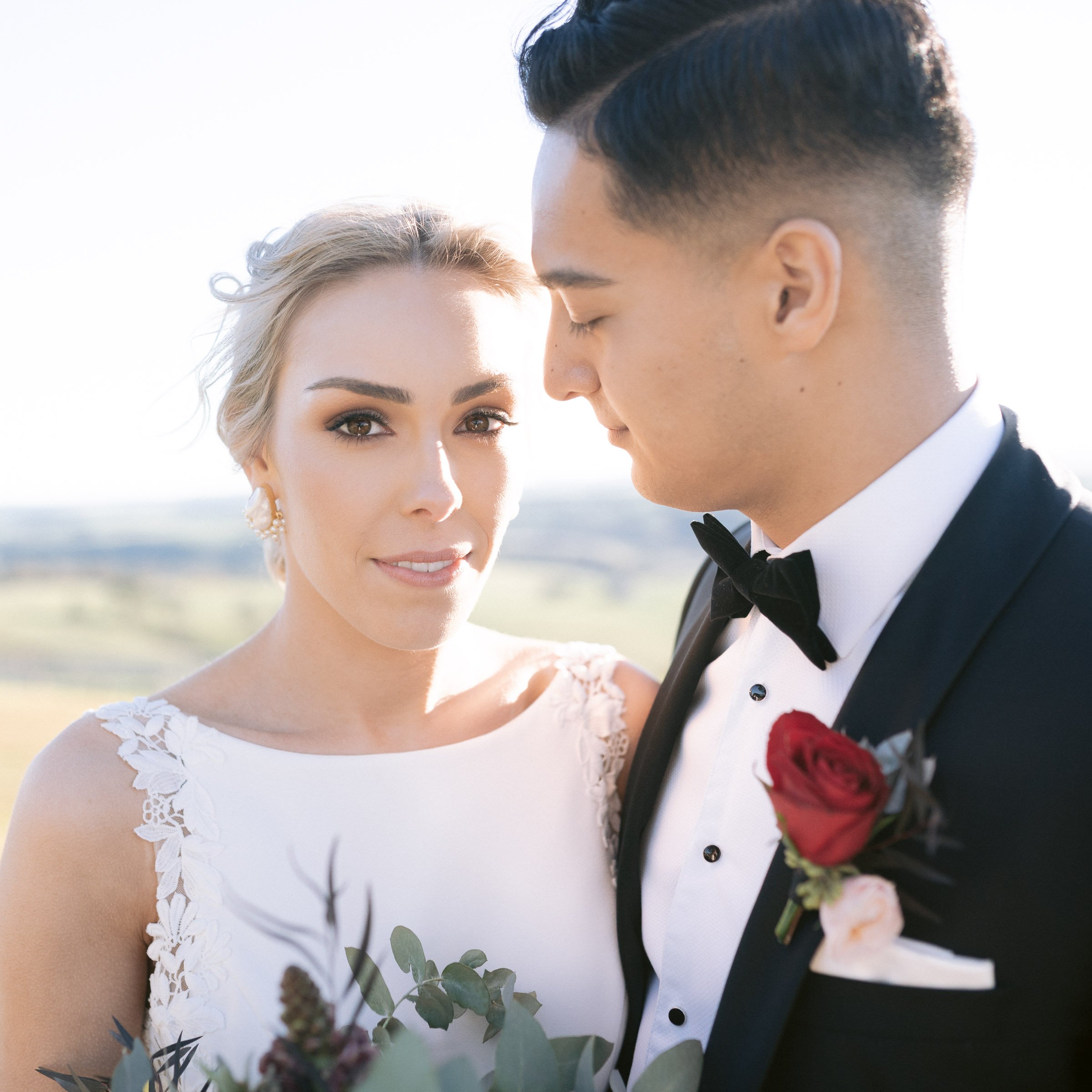 Bride and groom in formal attire, outdoor setting