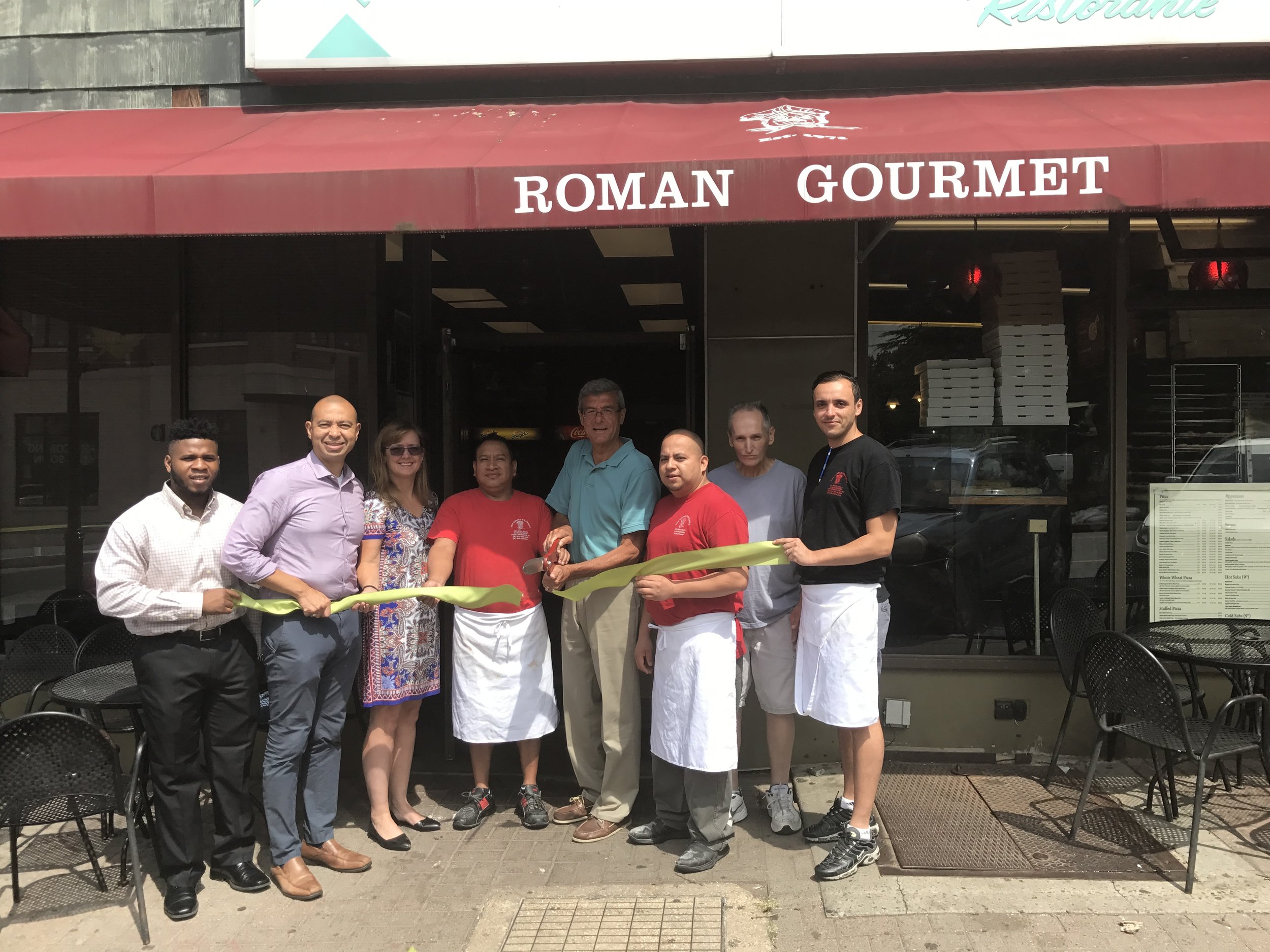 Left to right -- Uche Uneze (Maplewood Green Business intern), Township Committeeman Frank McGehee, Sheila Baker Gujral (Maplewood Environmental Advisory Committee), Johnny Calle (Roman Gourmet), Mayor Vic DeLuca, Pablo Carcamo (Roman Gourmet), John Brown (Roman Gourmet), and Lamine Ameur (Roman Gourmet)