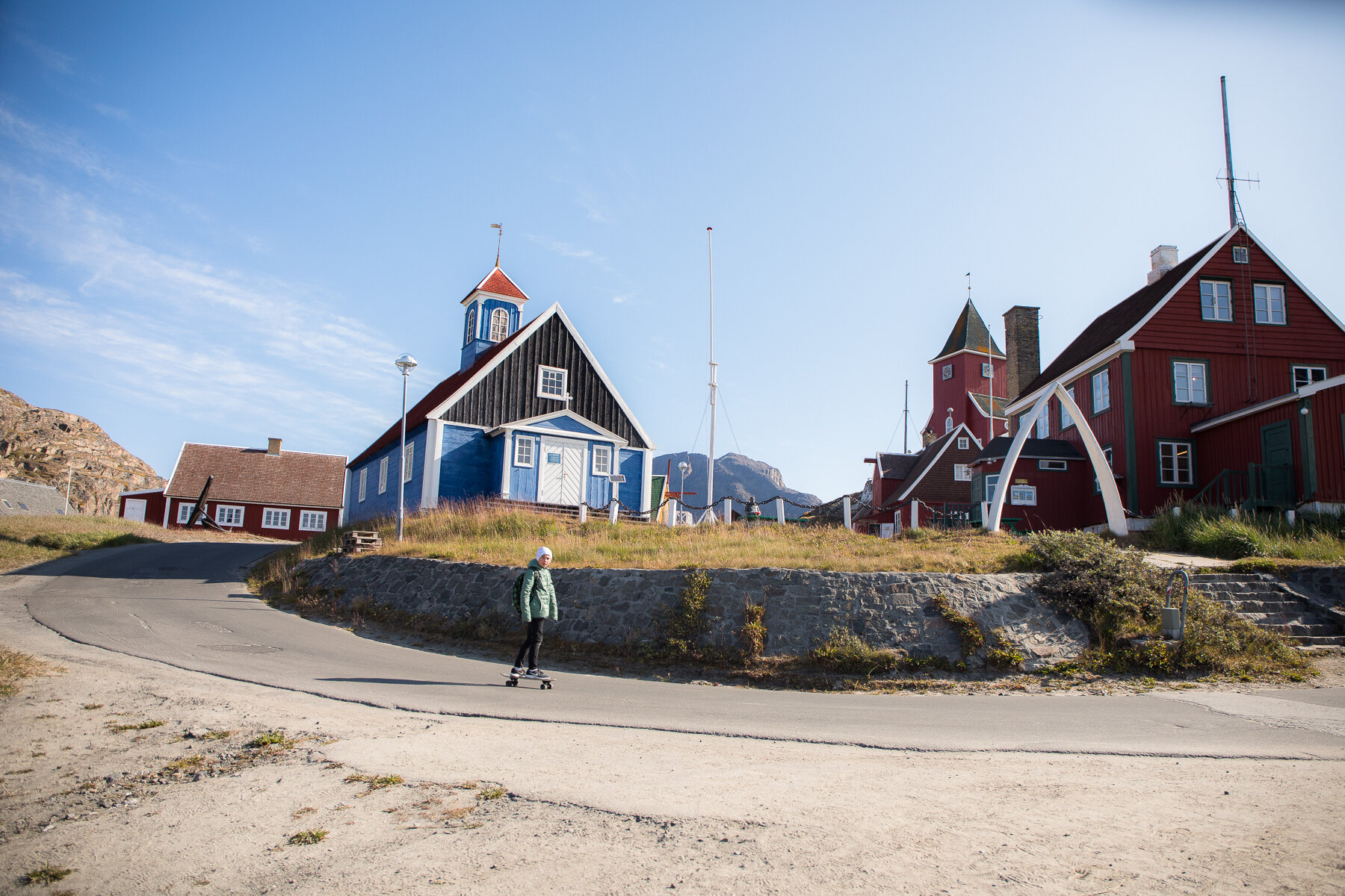  Greenland - Sisimiut- A young boy skateboards through town 