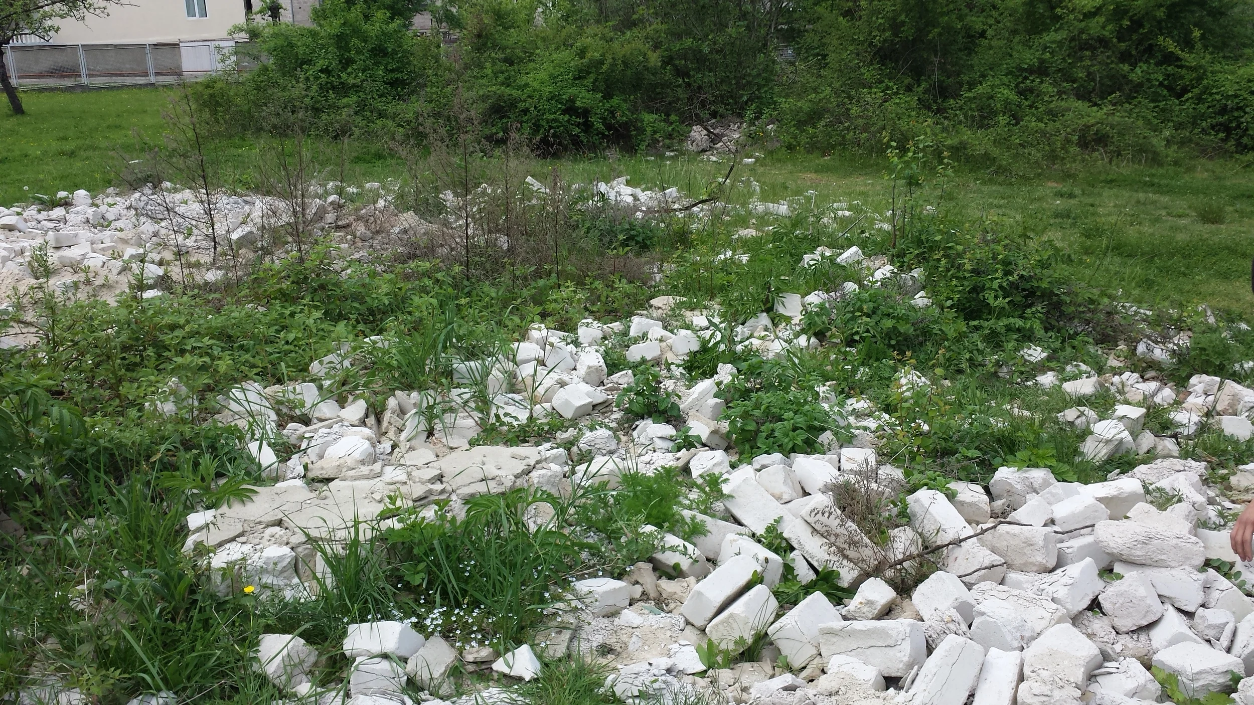 Our "stone quarry" in front of the school. You need a permit to haul these ruins off to a dump, which means they'll be sitting there as a useless pile forever... at least until we decided to use them!