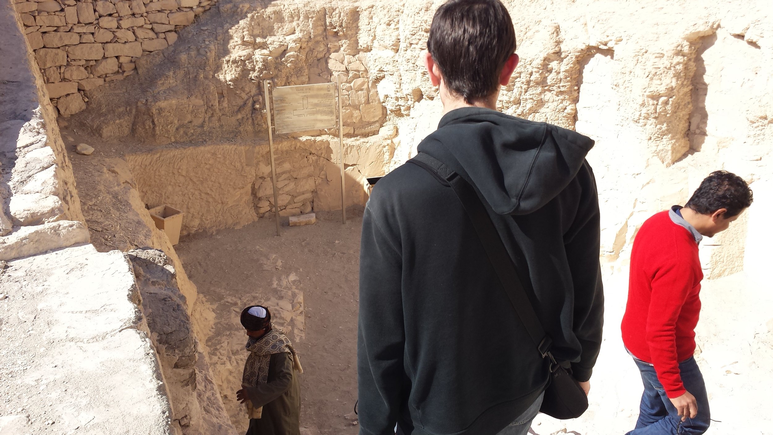 Stanley and our guide descend stairs while the guard at the bottom unlocks one of the tombs for us.