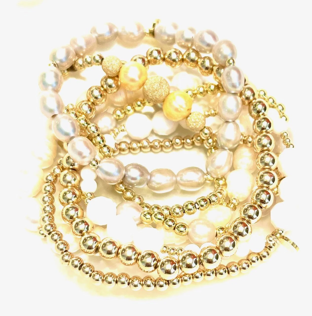 stack of pearls and gold bead bracelets.jpeg