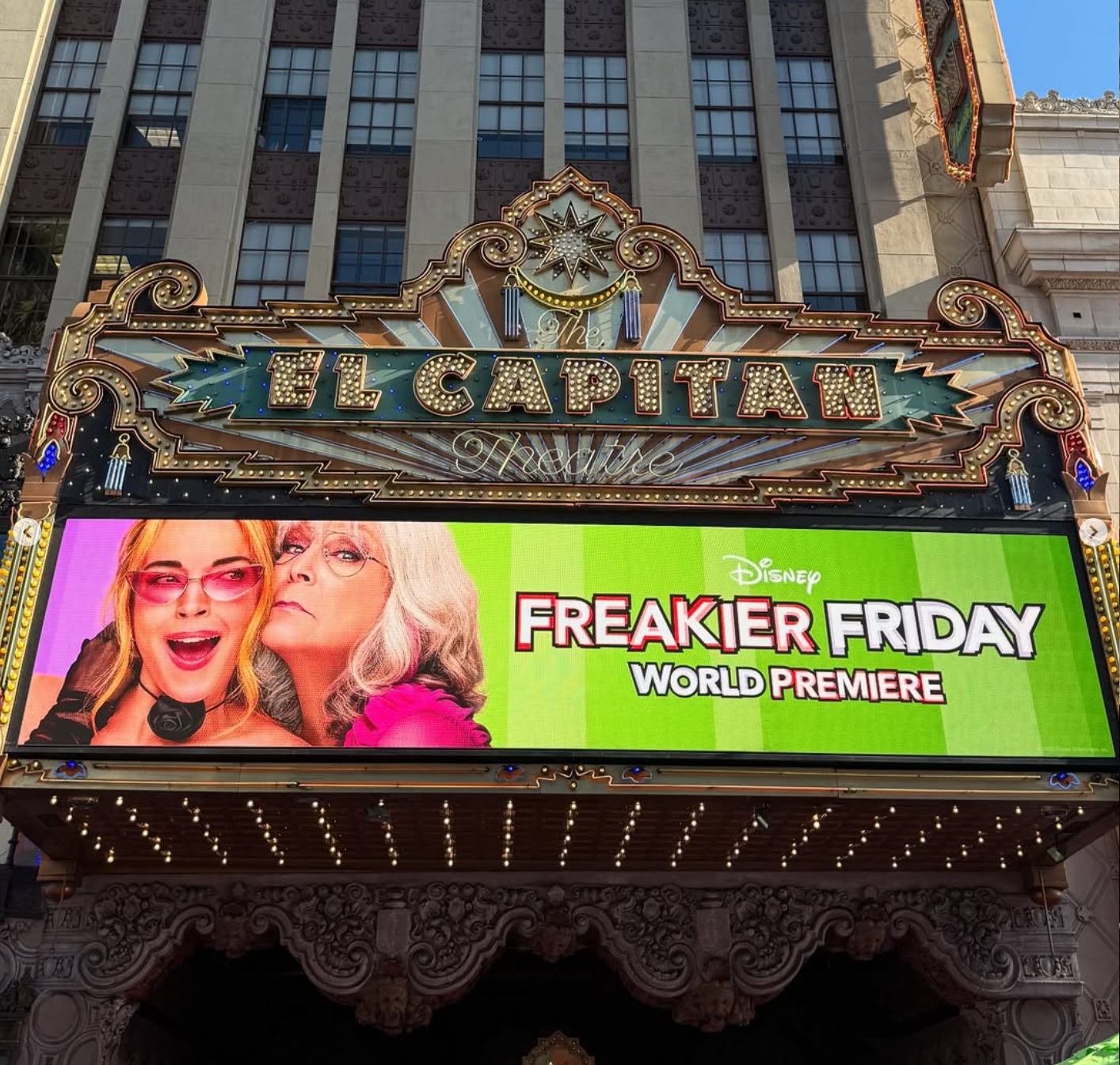 The El Capitan Theatre marquee displaying a poster for Disney's Freakier Friday world premiere featuring two women, one with red hair and the other with gray hair, with bold, colorful text.