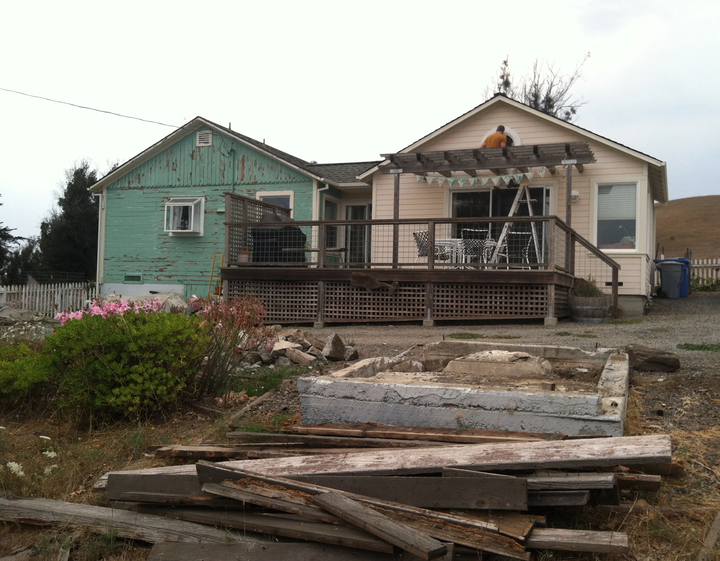 MAIN HOUSE: Two of the main house structures. The green one is the original house and the yellow portion was added on almost 15 years ago. The concrete mess is an abandoned well that we had jackhammered shortly after this photo. We're in the hauling junk off our property phase now.