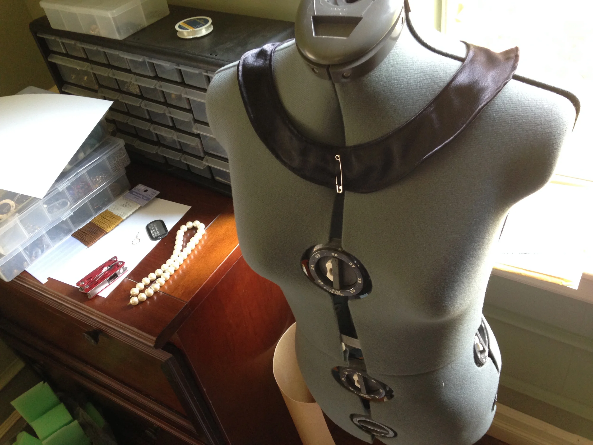 This is the necklace base, with the pearl strand on the desk which will be added later