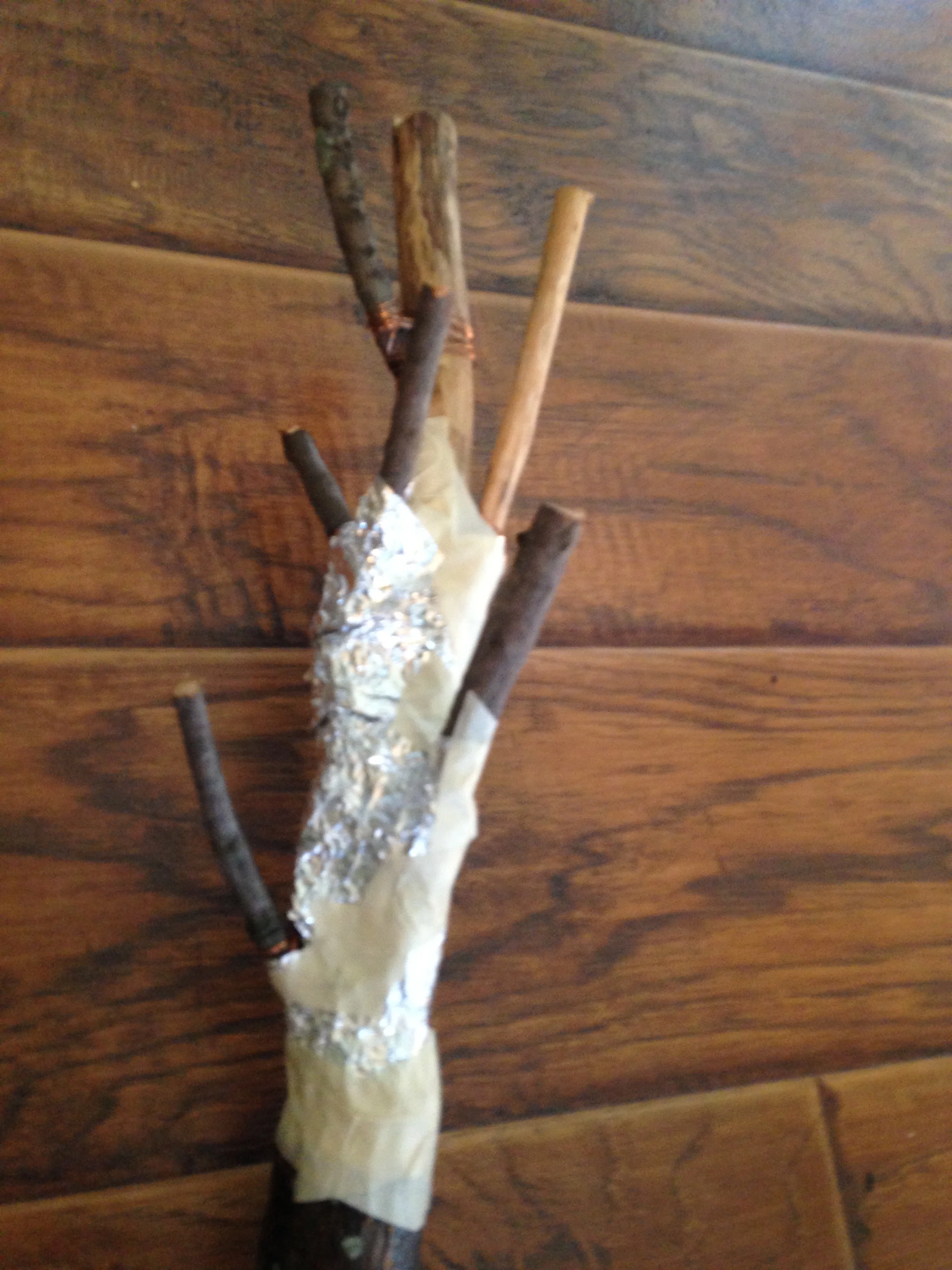 The staff started with a big branch and a bunch of little branches... and some tin foil and masking tape. Don't judge the jankiness, just wait til you see how it turned out!