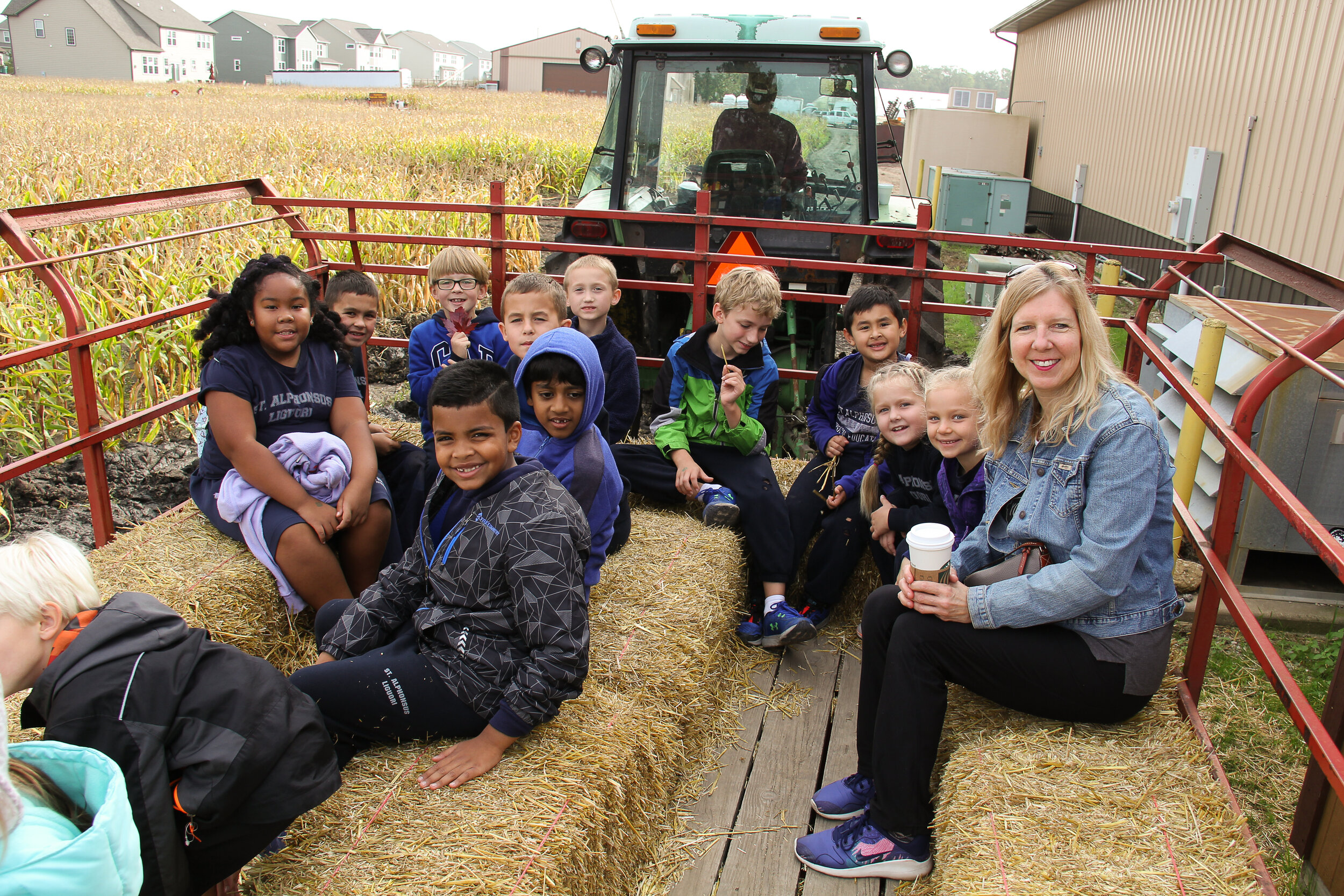  Second grade students are on a field trip.  They are sitting on a hayride. 