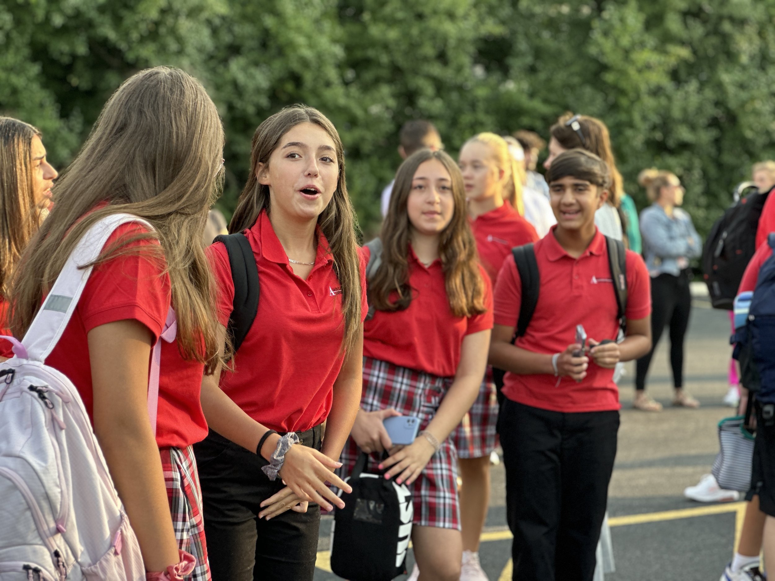  Seventh grade students are talking and laughing while lining up outside on the first day of school 