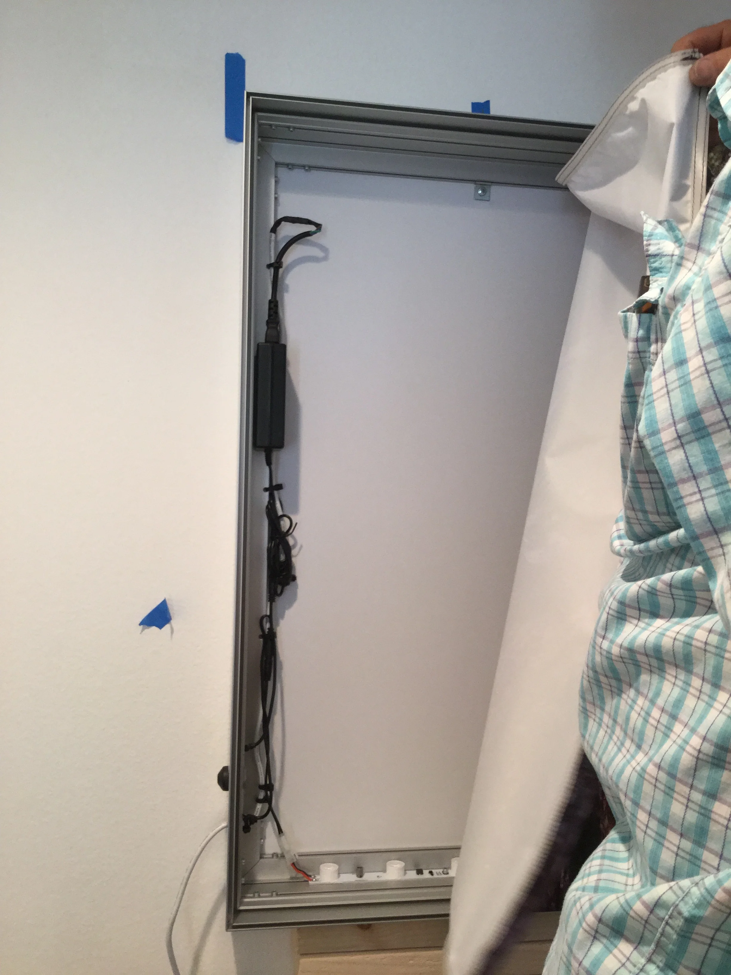 Taking back the canvas to attach the support to the wall.