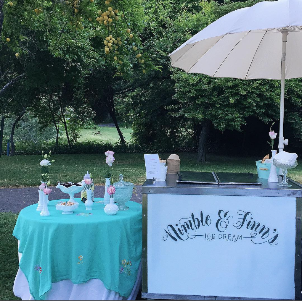 ice cream catering cart and topping table at a wedding.png