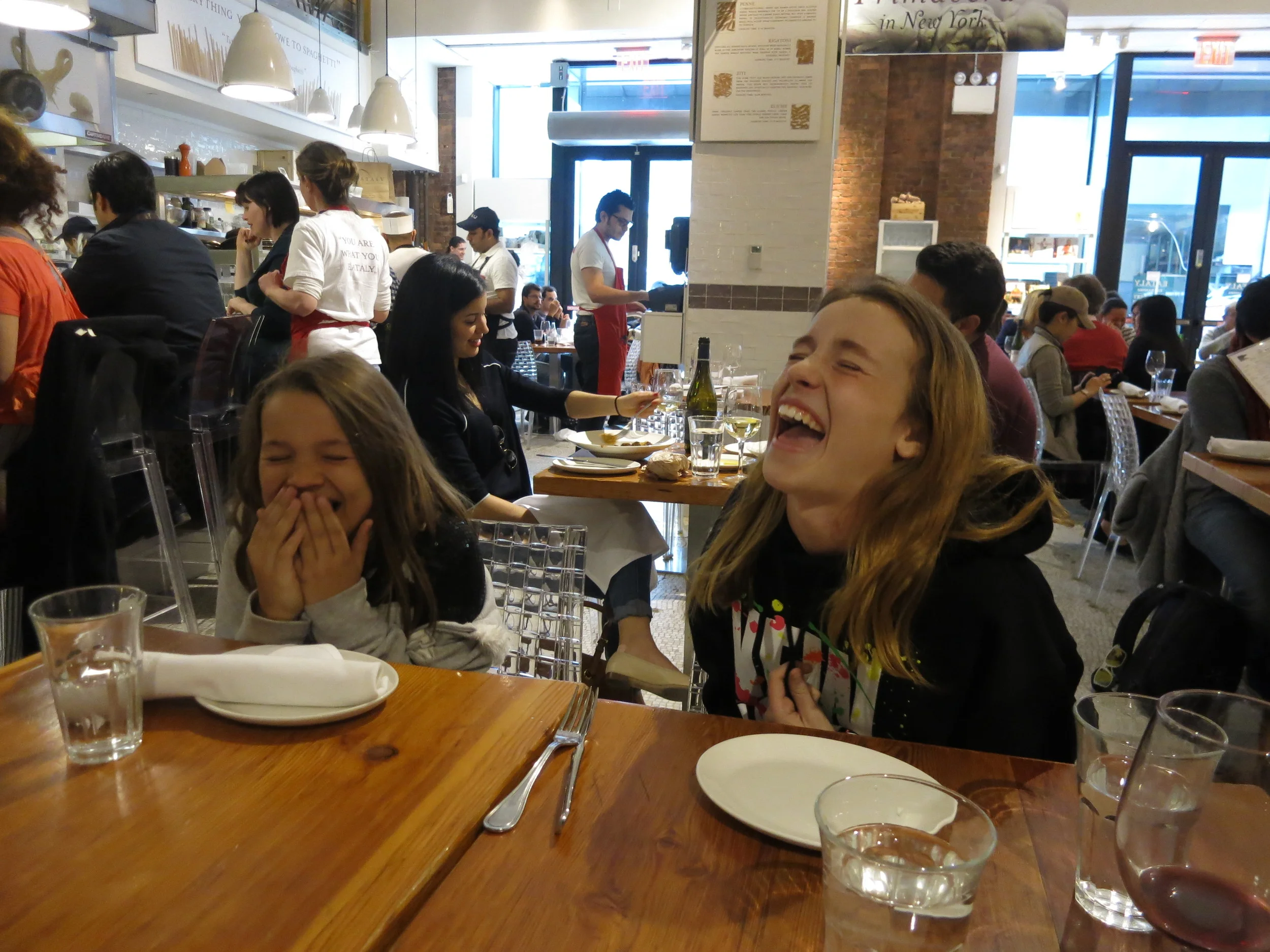 Sophia and Isabella Candelaria sharing a laugh at Eataly, NYC