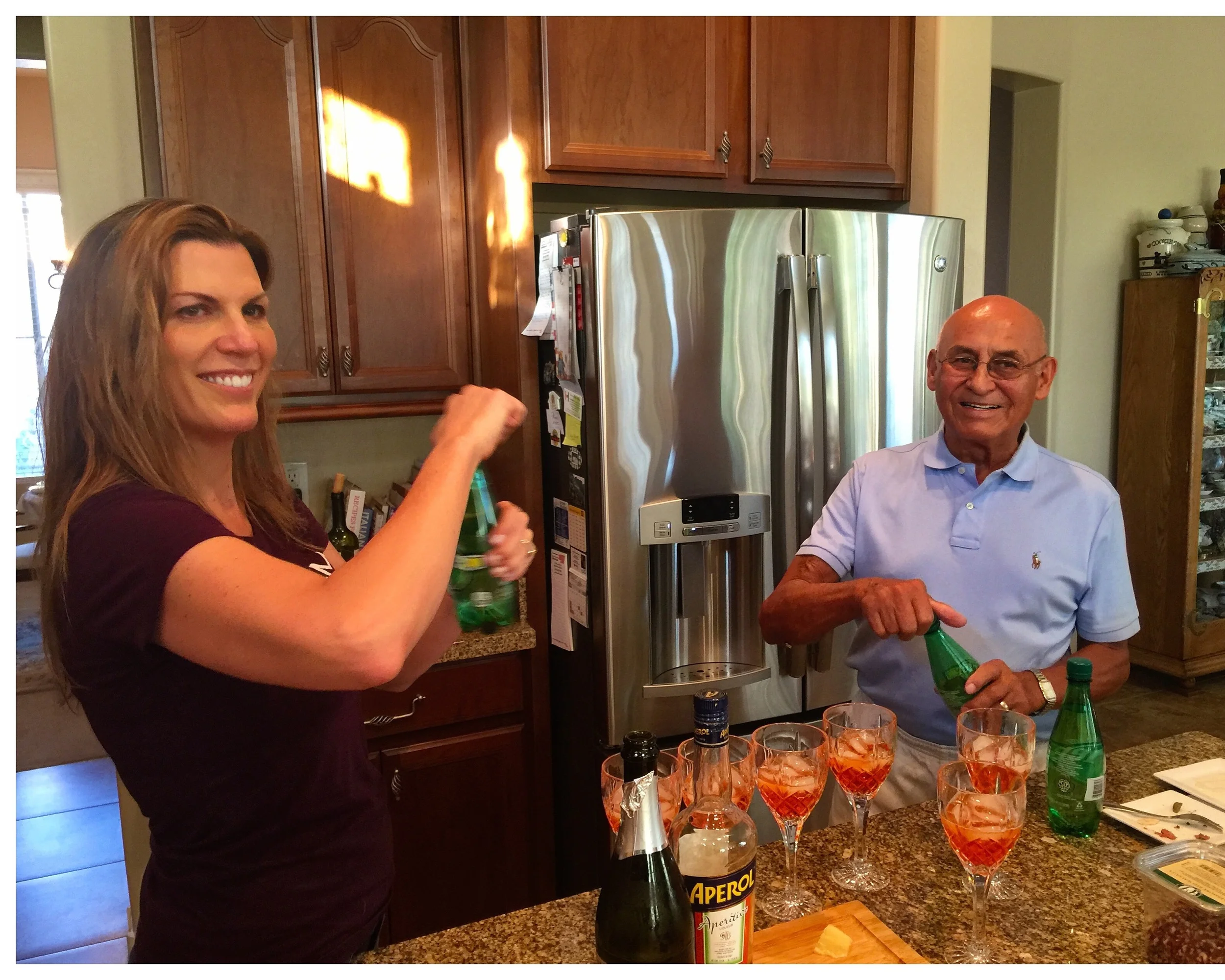 Isabel fixing Aperol Spritzs with Grandpa Don Candelaria