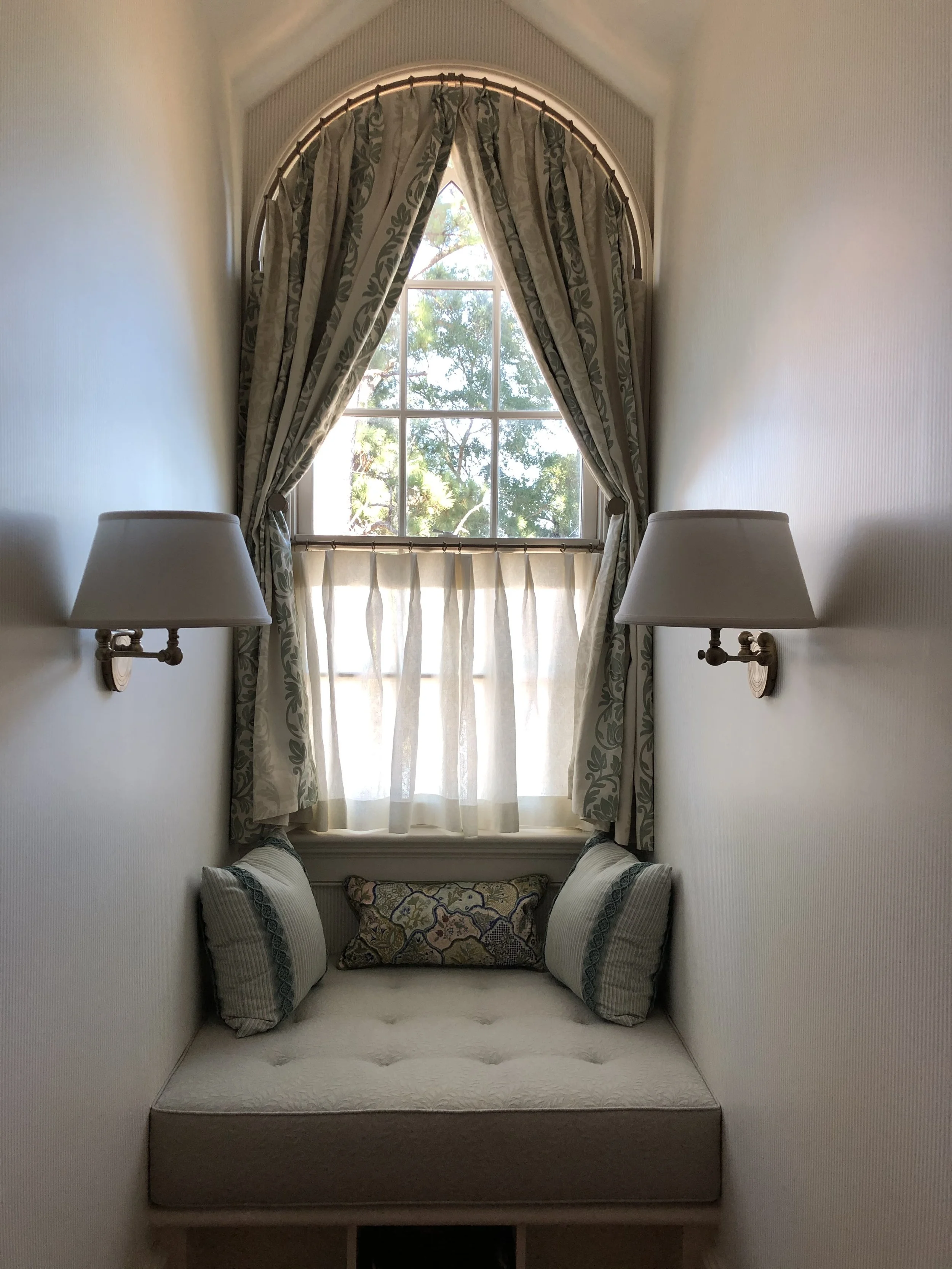 Custom drapes on custom bent rod and café curtain during installation, by Savannah Window Fashions.