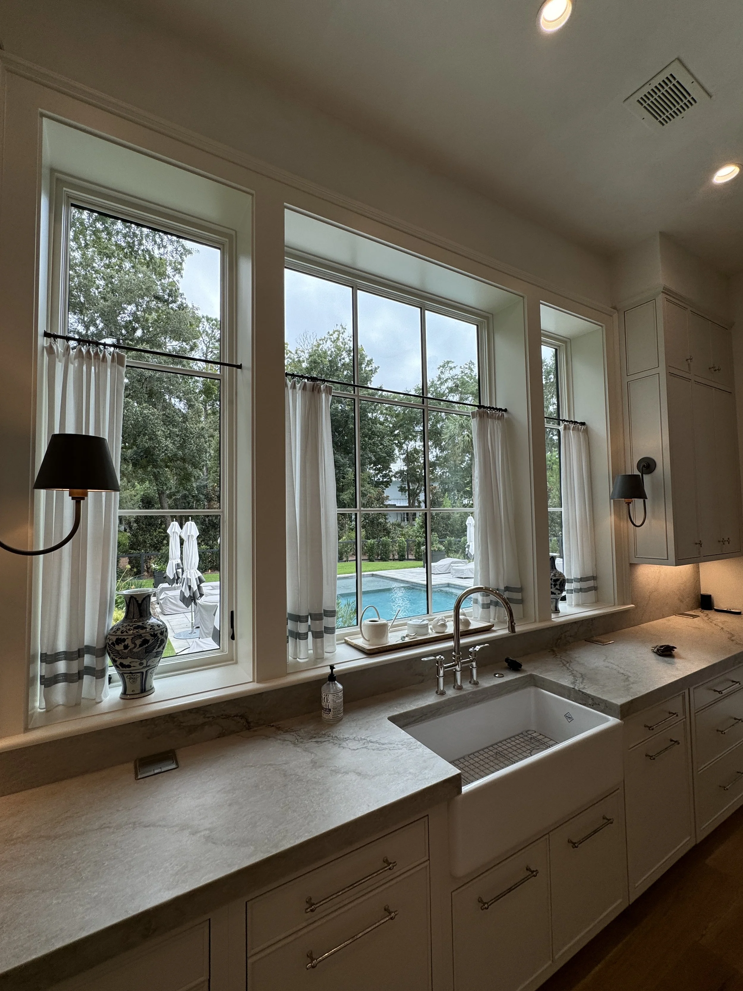Café curtains add sophistication to this kitchen. Designed by Sarah Bartholomew Designs.
