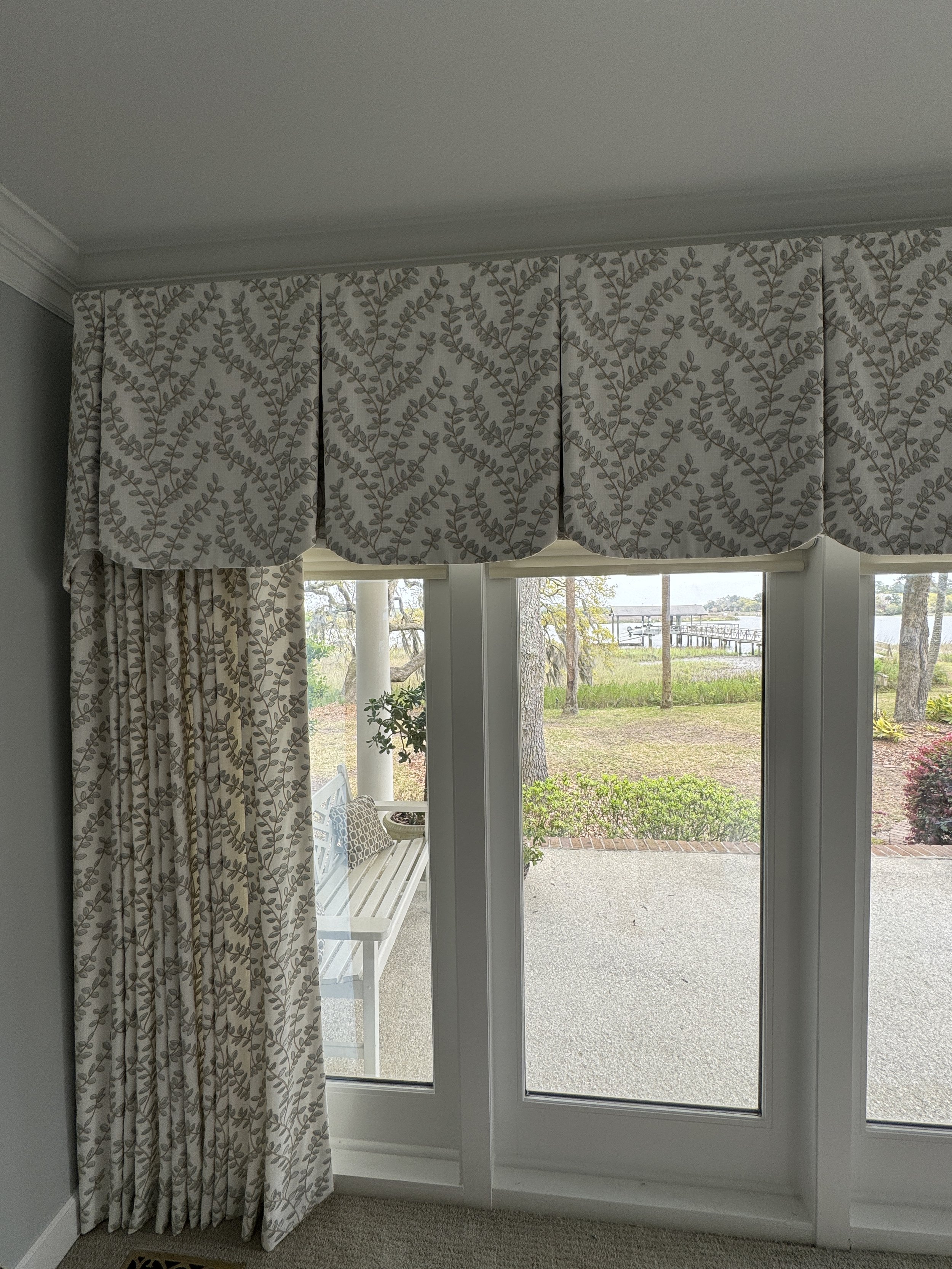   This pleated valance is layered over draperies and roller shades to hind the roller shade cassette and cover the transom windows in this Low Country home on Dutch Island.  