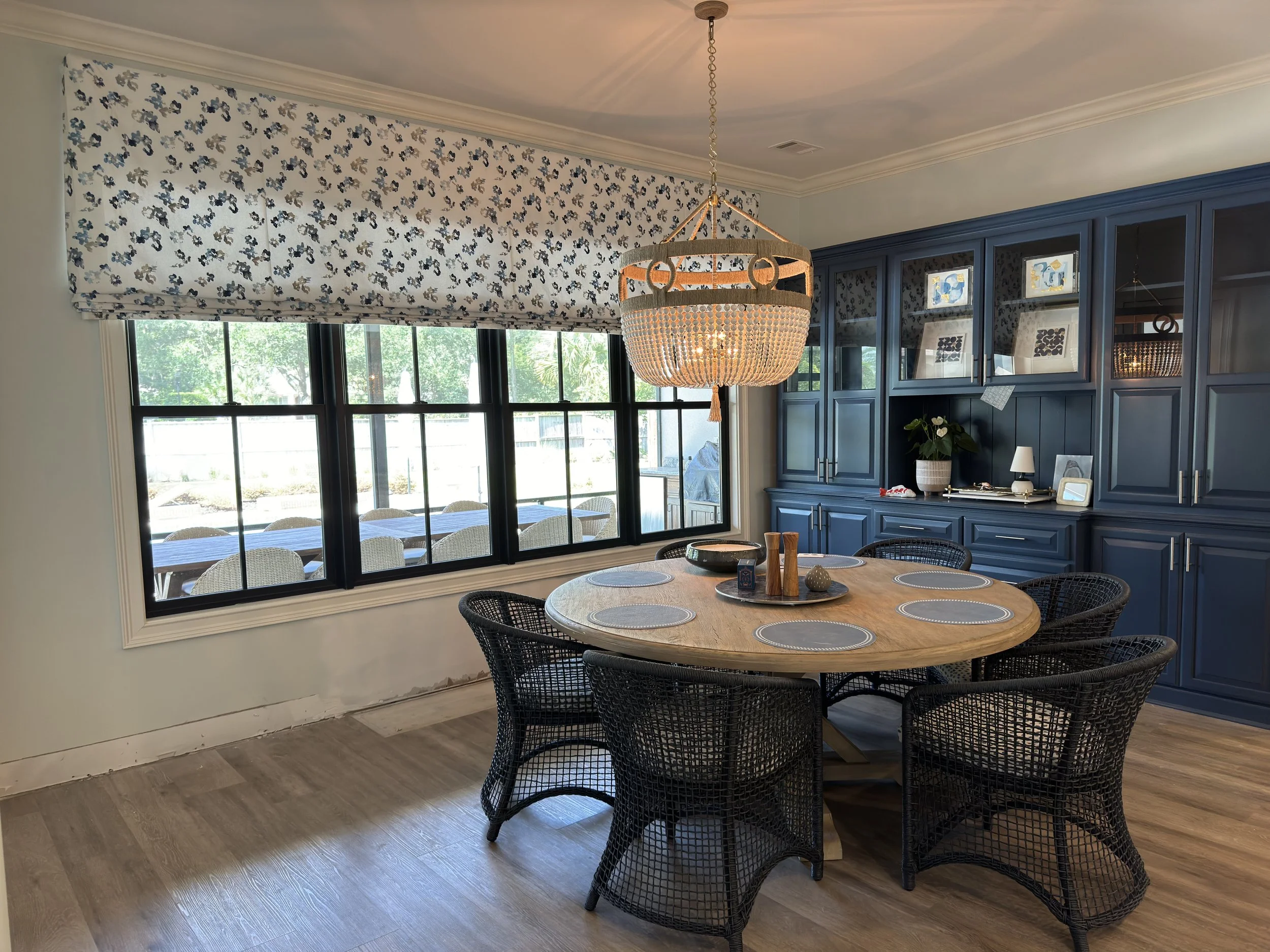 Custom patterned faux Roman valance brings charm to this casual dining area. Design by Deringer Design.