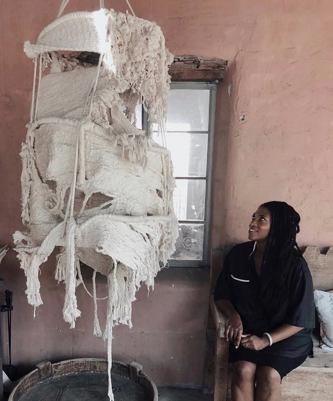 The female artist Amber Doe looking at her cotton sculpture called "Self-Portait"