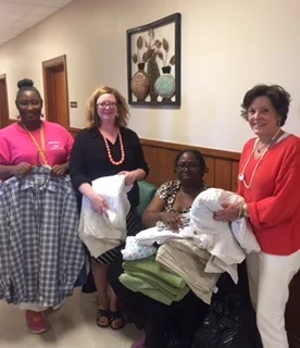 Candace Chase (left), emergency assistant/volunteer coordinator at St. Gabriel Mercy Center; Heather Miller, the Delta Center; Mavis Honorable, SGMC assistant director; and Lee Aylward, the Delta Center, recently sorted linens donated by participants in this summer's Delta Center workshops.