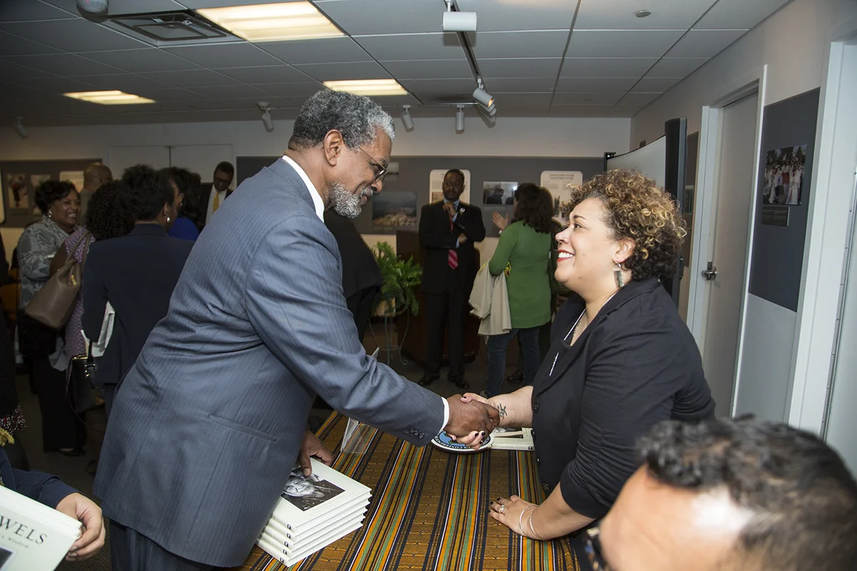 Alysia Burton Steele shakes hands with James Frazier, Chair of the Smithsonian Anacostia Community Museum Advisory Board. (Photo courtesy of Smithsonian Institution)