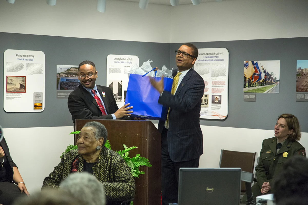 Dr. Rolando Herts gives a token of appreciation to Mossi Tull on behalf of The Delta Center and the Mississippi Delta National Heritage Area. Tull sponsored travel for Delta Jewel Annyce P. Campbell and her family, as well as Reena Evers, to participate in the Delta Jewels program at Smithsonian Anacostia. (Photo courtesy of Smithsonian Institution)
