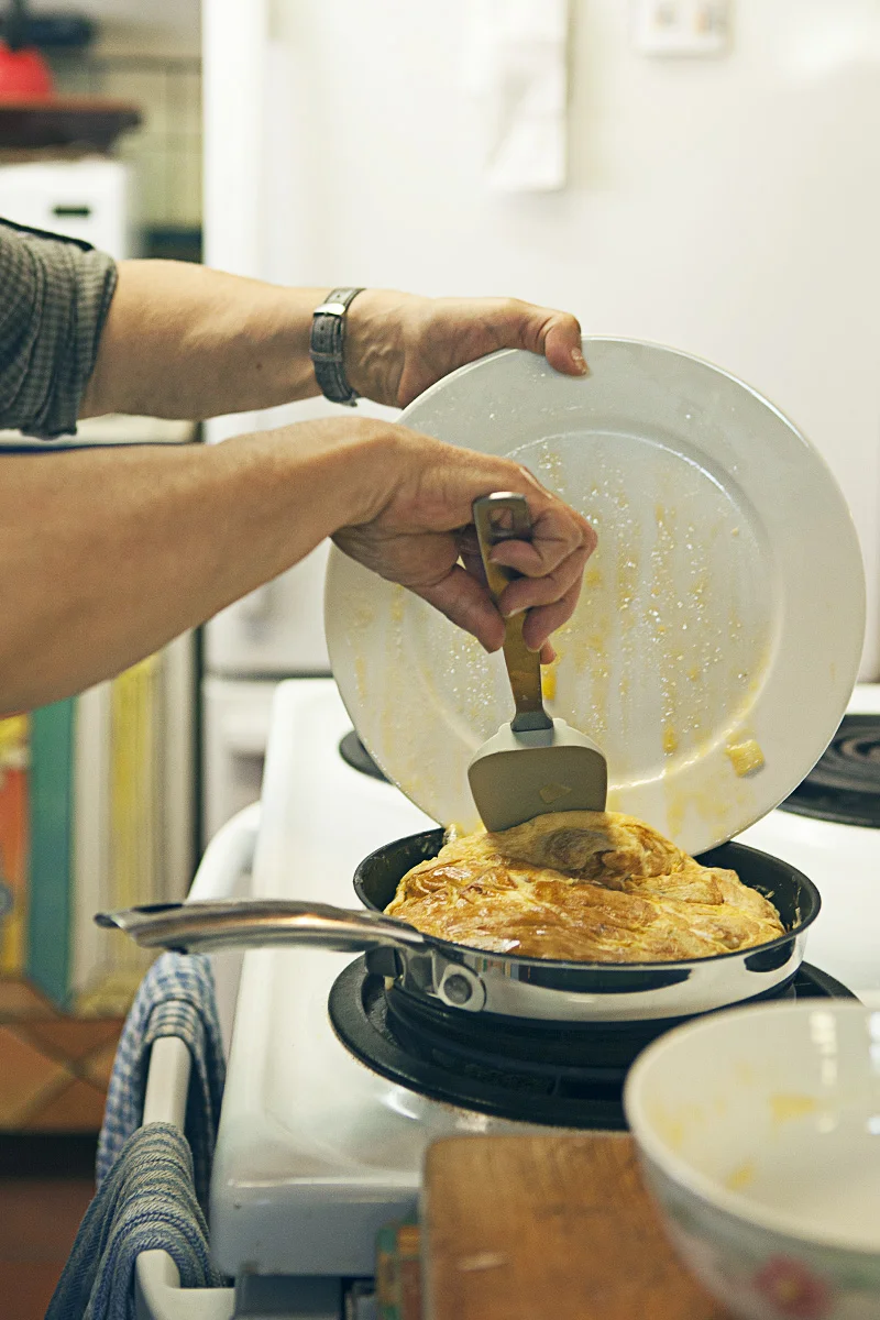 Rita first plate-to-pan frittata flip. She does this around three times to ensure no wet yolks remain in the finished dish.