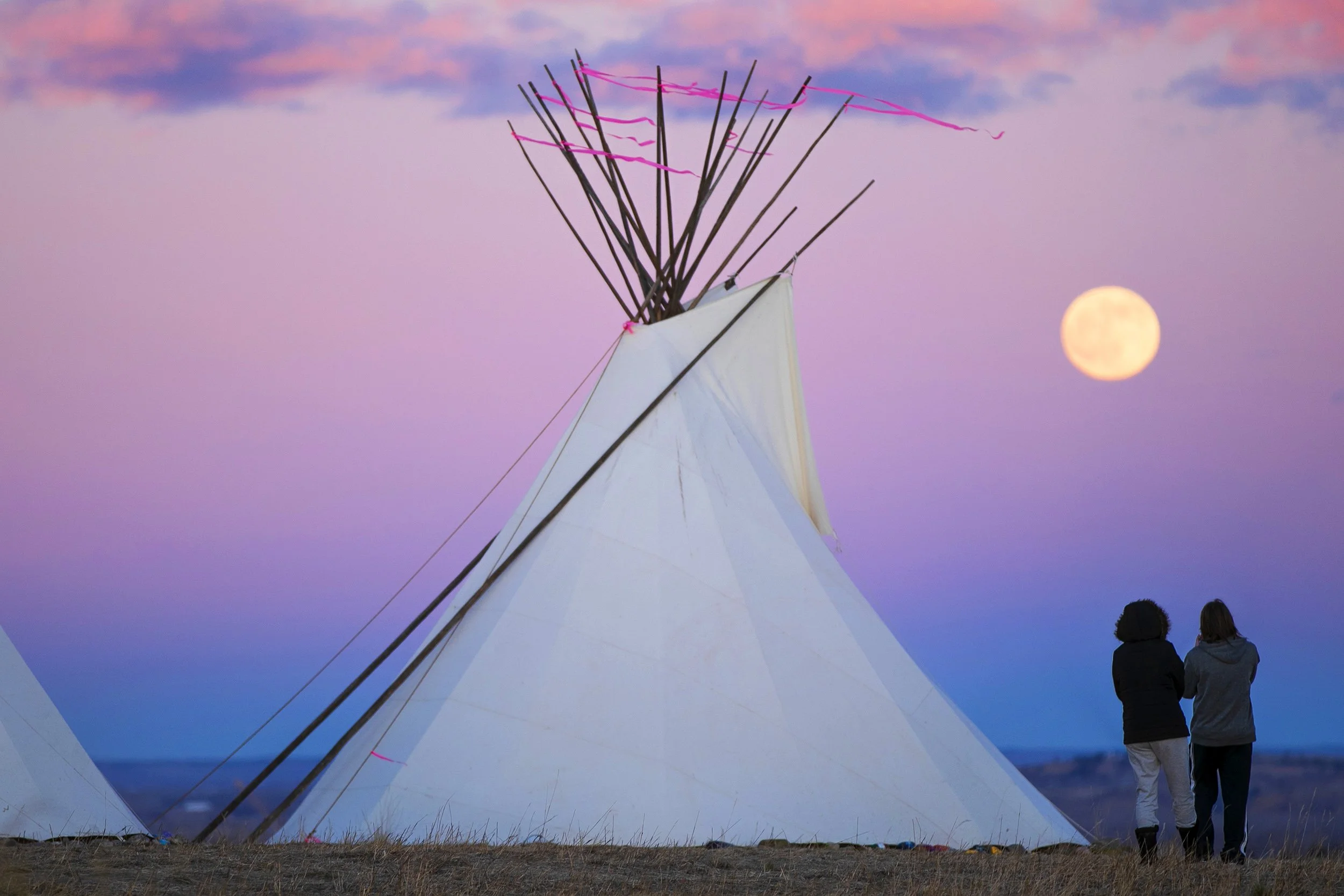  A couple watches the Cold Moon rise while standing amongst "The Lighting of the Teepees: A Symbol of Hope" at Swords Park Tuesday, Dec. 29, 2020 in Billings, Montana.  