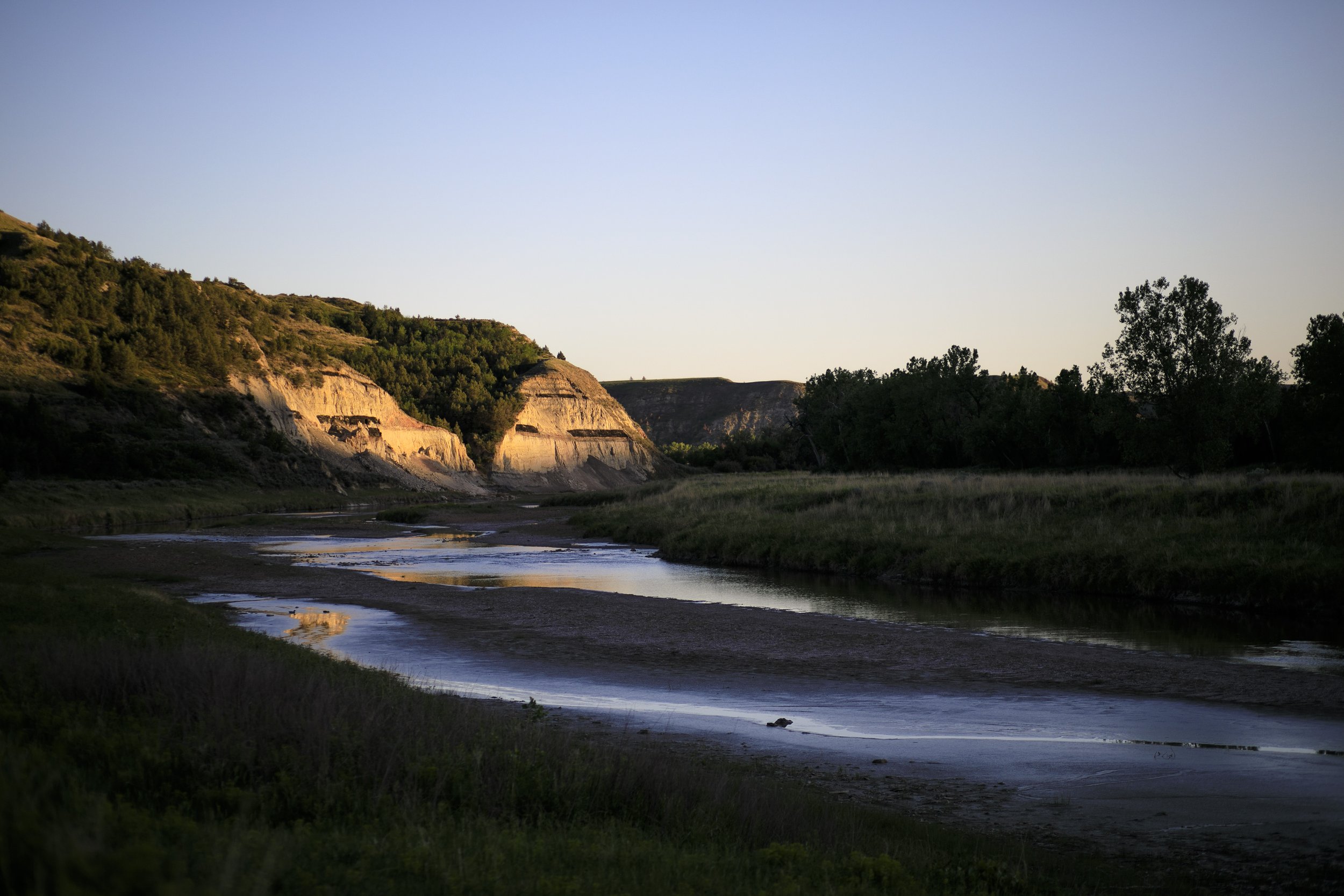  The sunset shines on a cliff along the Little Missouri River on June 12, 2021 in Theodore Roosevelt National Park, North Dakota. 