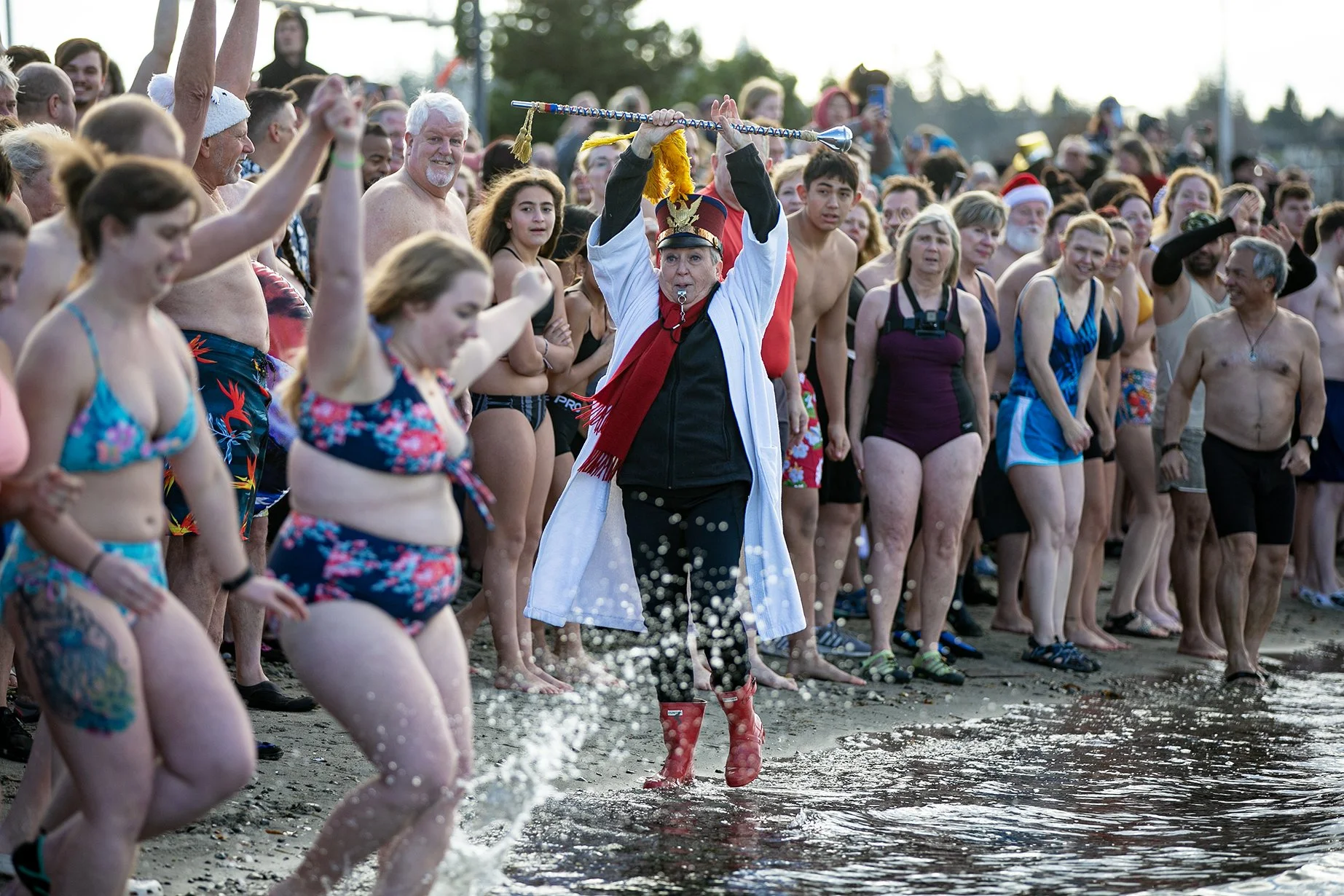 Edith Farrar watches as people begin to run into the ocean — perhaps a moment too early — during the 2023 Edmonds Polar Bear Plunge on Sunday, Jan. 1, 2023, at Brackett’s Landing in Edmonds, Washington.