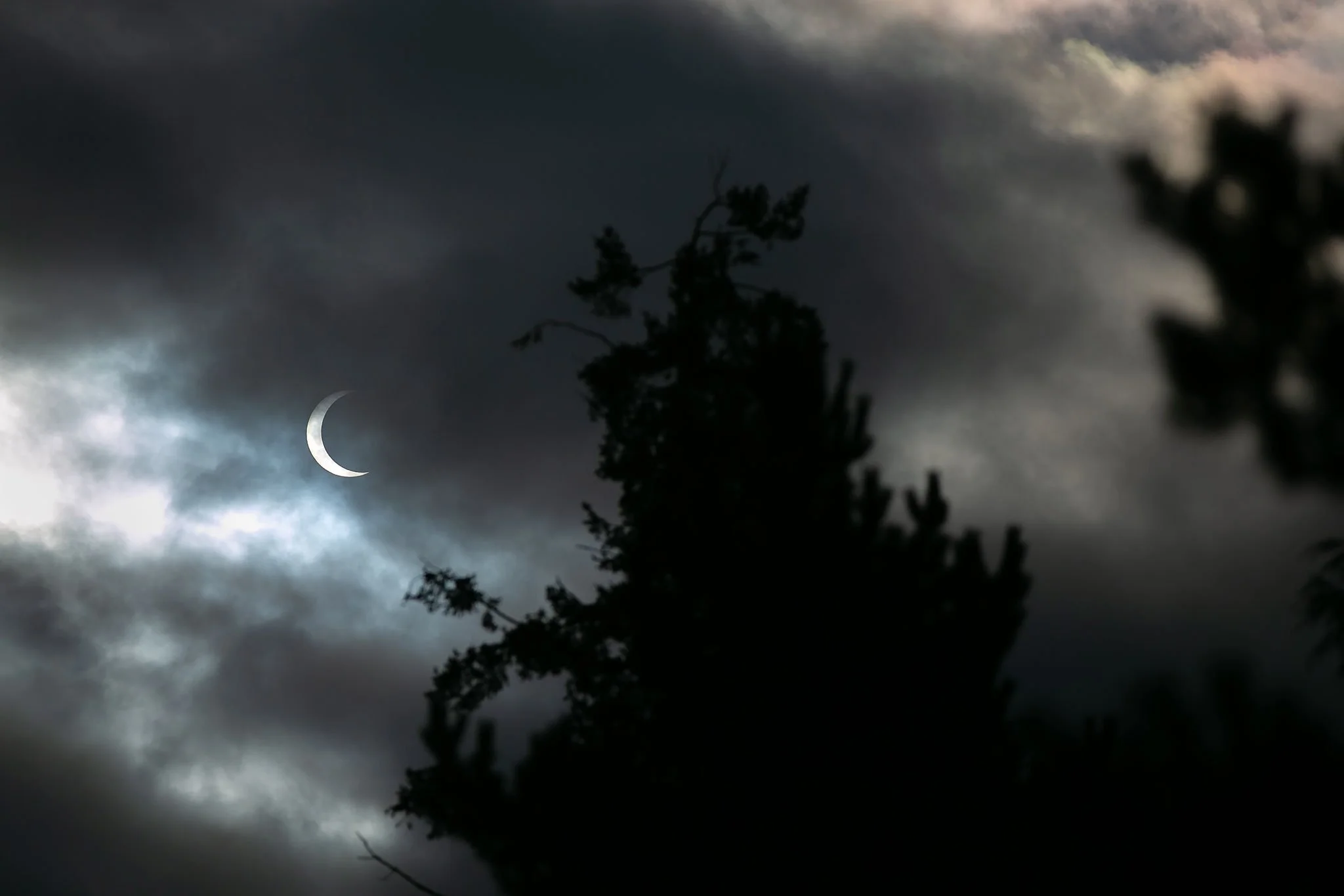  Clouds pass in front of the moon and sun as the two cross paths during an annular eclipse on Saturday, Oct. 14, 2023, seen from Everett, Washington. A total eclipse will be visible over parts of the United States in April 2024. 