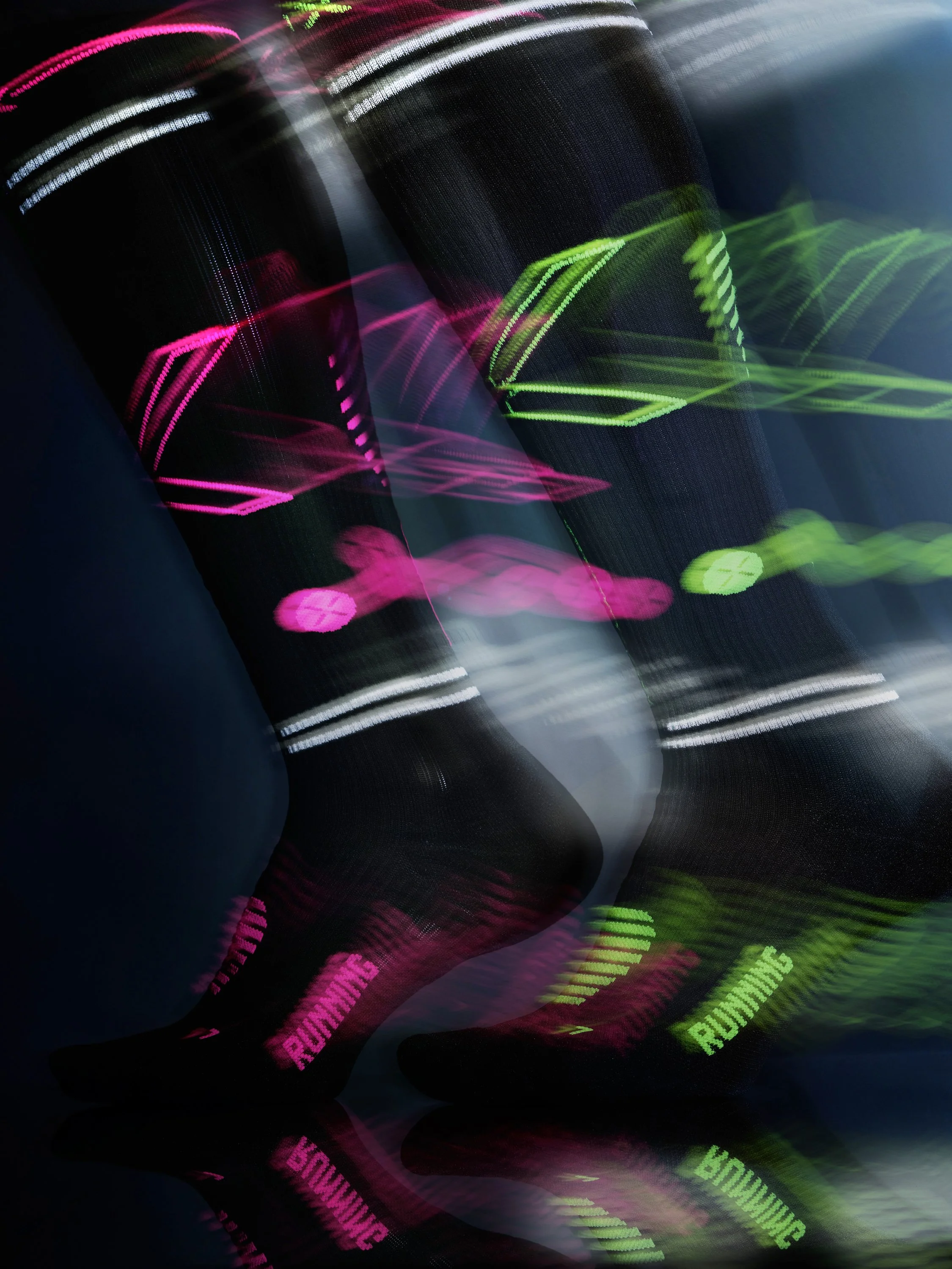 a studio shot for Stox energy socks with fluorescent stripes moving in a dark studio several colours pink and green