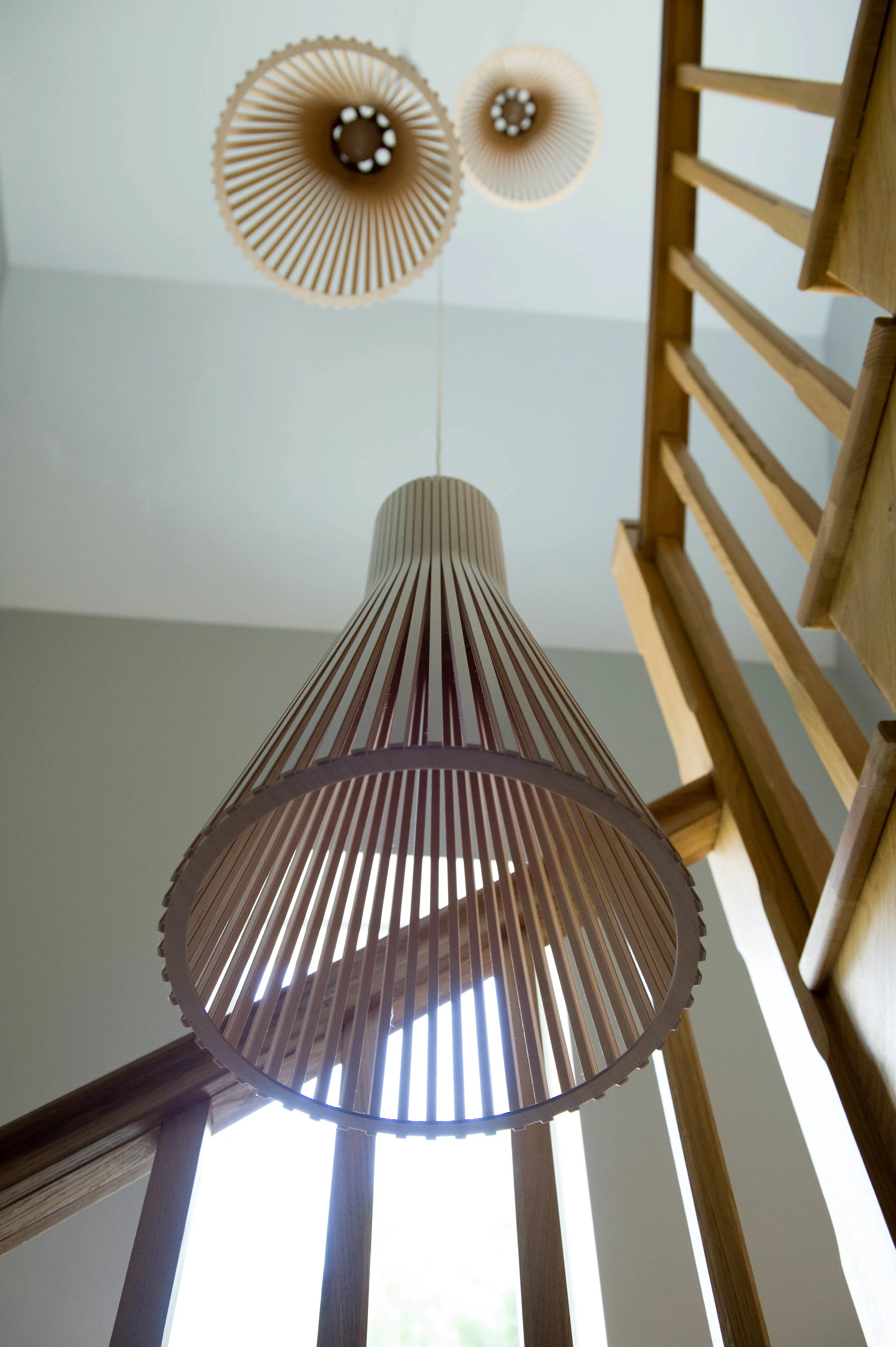 Cluster of three modern, timber pendant lights by Secto Lighting.