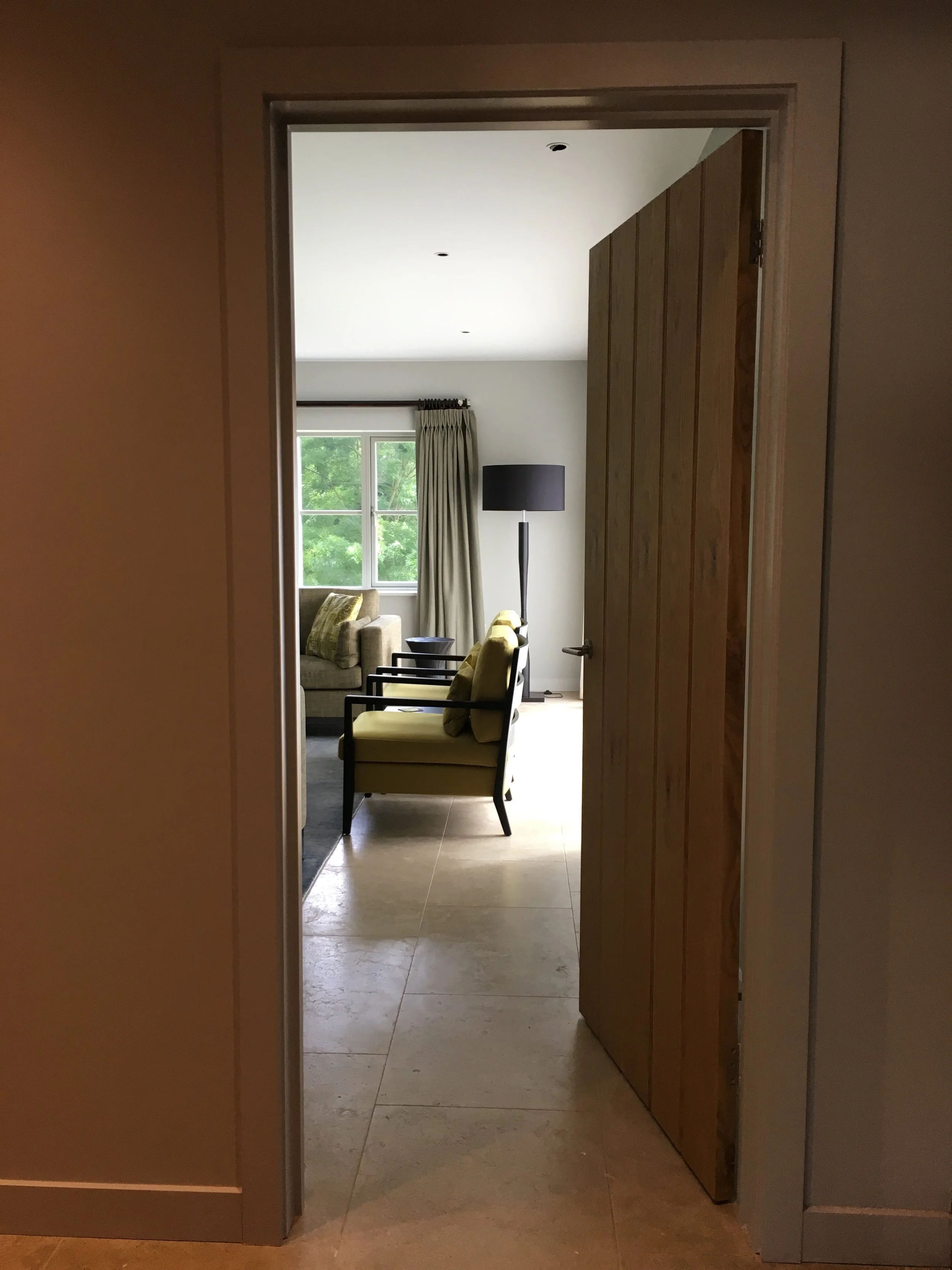 View of contemporary armchairs through a doorway. By Joseph Interior Design, Cheltenham.