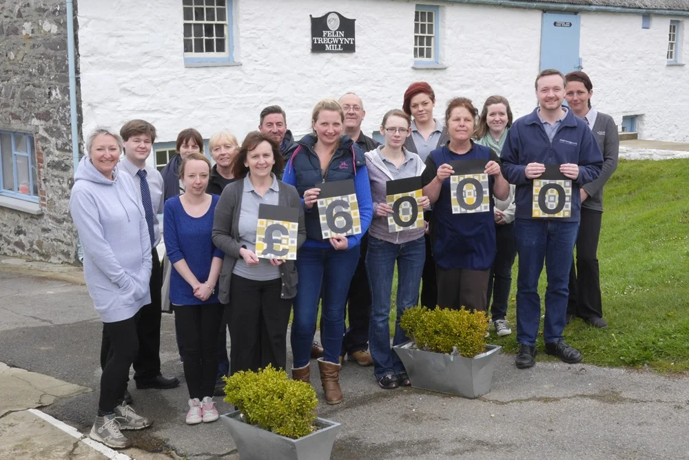 Staff at the mill with the amount collected for the Community Fund from the sale of the special Community Fund blanket.