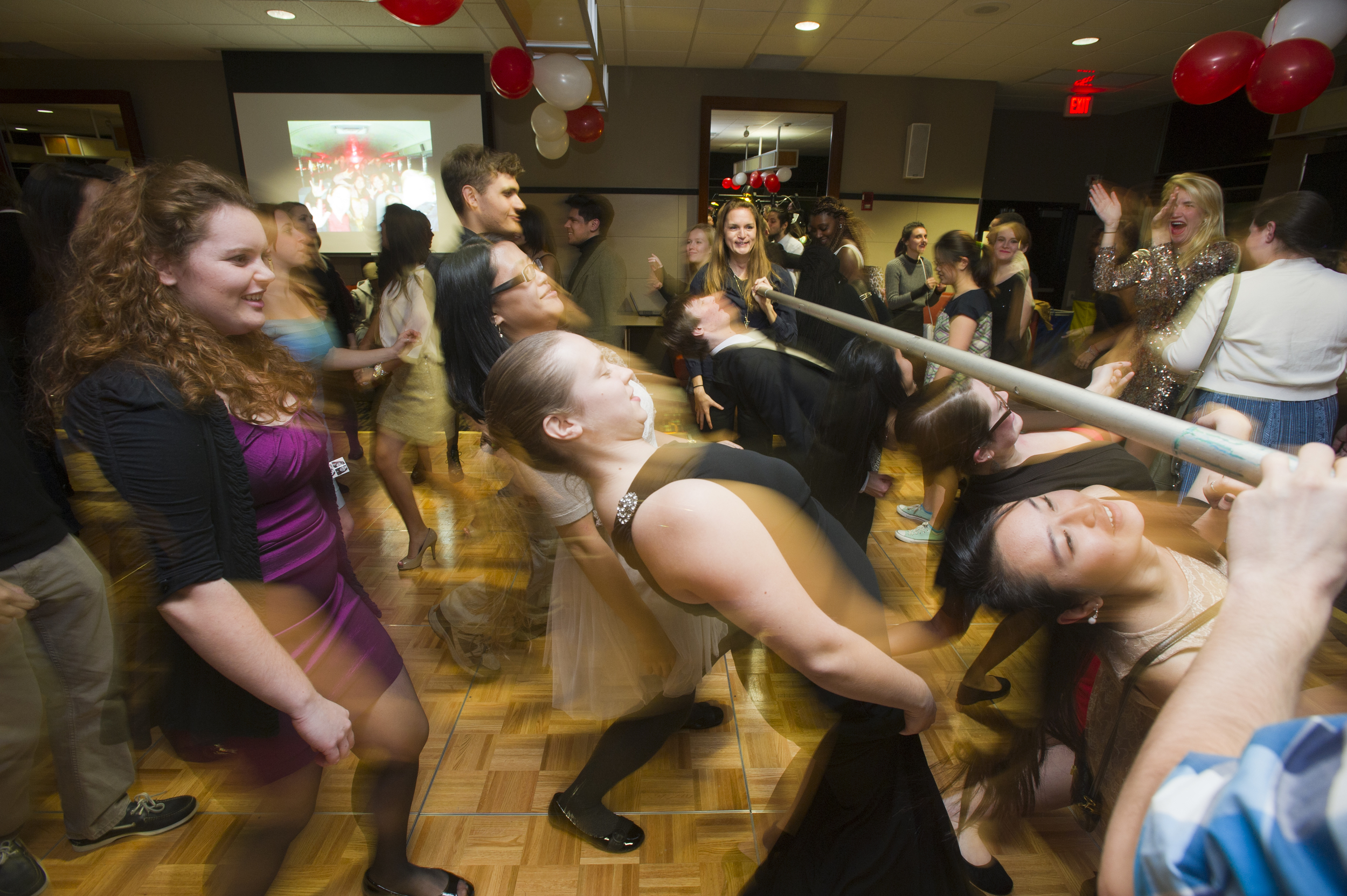  Revelers take on a limbo pole during the Deaf Studies Club ASL Ball November 14, 2014 in the GSU backcourt. &nbsp;Photo by Cydney Scott for Boston University Photography 