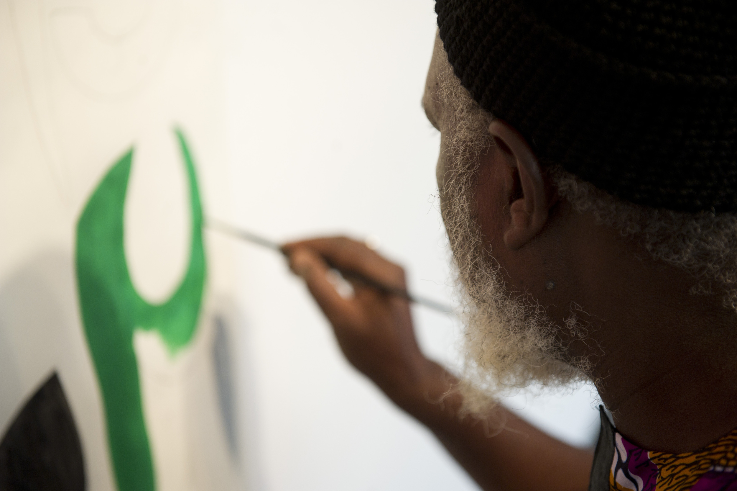  Artist Yelimane Fall of Senegal works on the beginnings of a mural while the rest of his work is installed for an exhibit in the GSU Gallery, November 9, 2011.&nbsp;Photo by Cydney Scott for Boston University Photography 