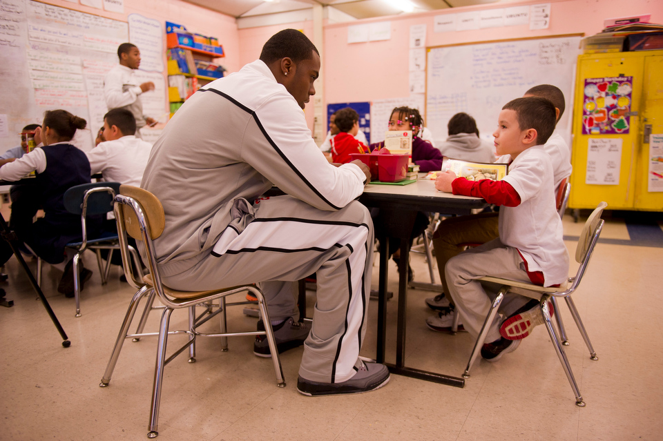  James Kennedy (CGS'15), left, chats with Henry Reynoso, a second grader at Blackstone Elementary, during a visit to the class Decemeber 13, 2012. Members of BU's basketball team read with children in Sterling Scott's second grade classroom at Blacks